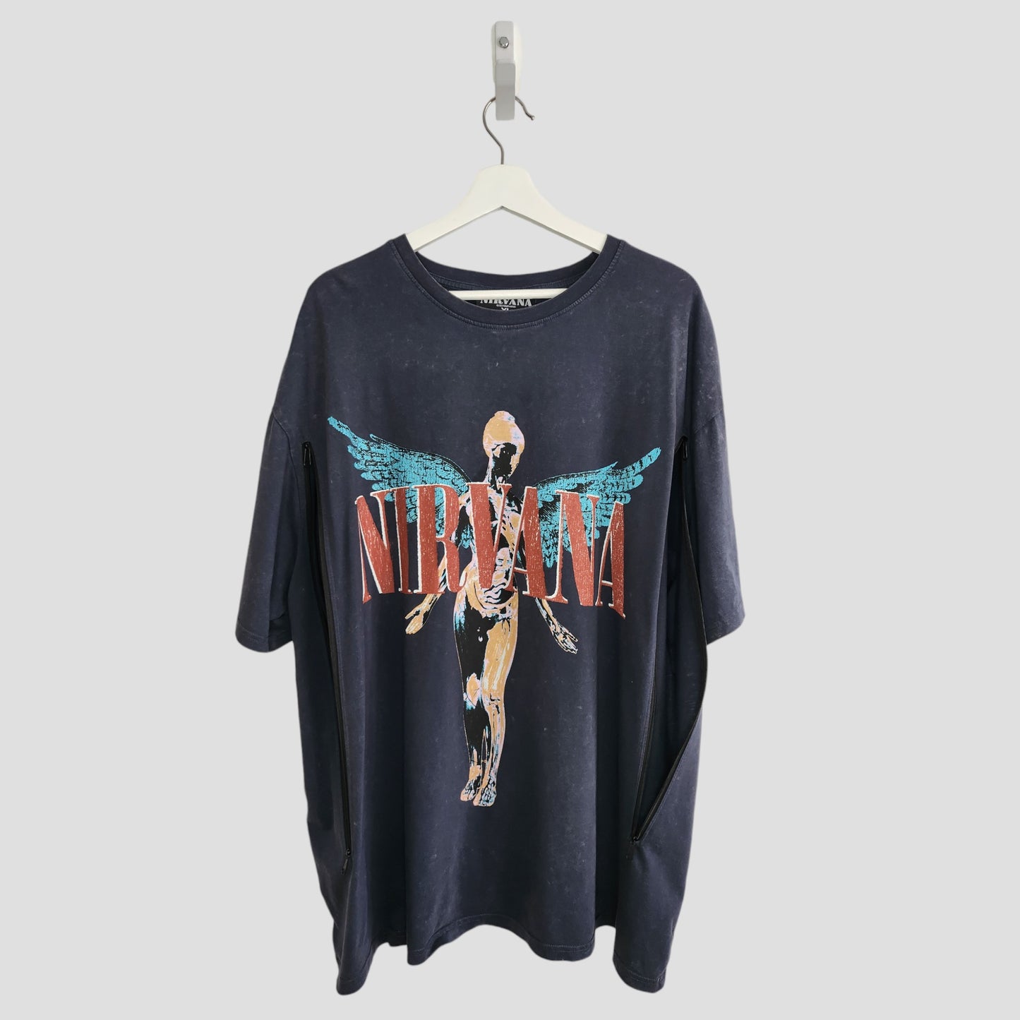 An upcycled grey/turquoise Primark Nirvana Angel Band t-shirt (XL UK18/20), designed for breastfeeding and pumping, offers a unique preloved look for music fans seeking comfortable, practical style.