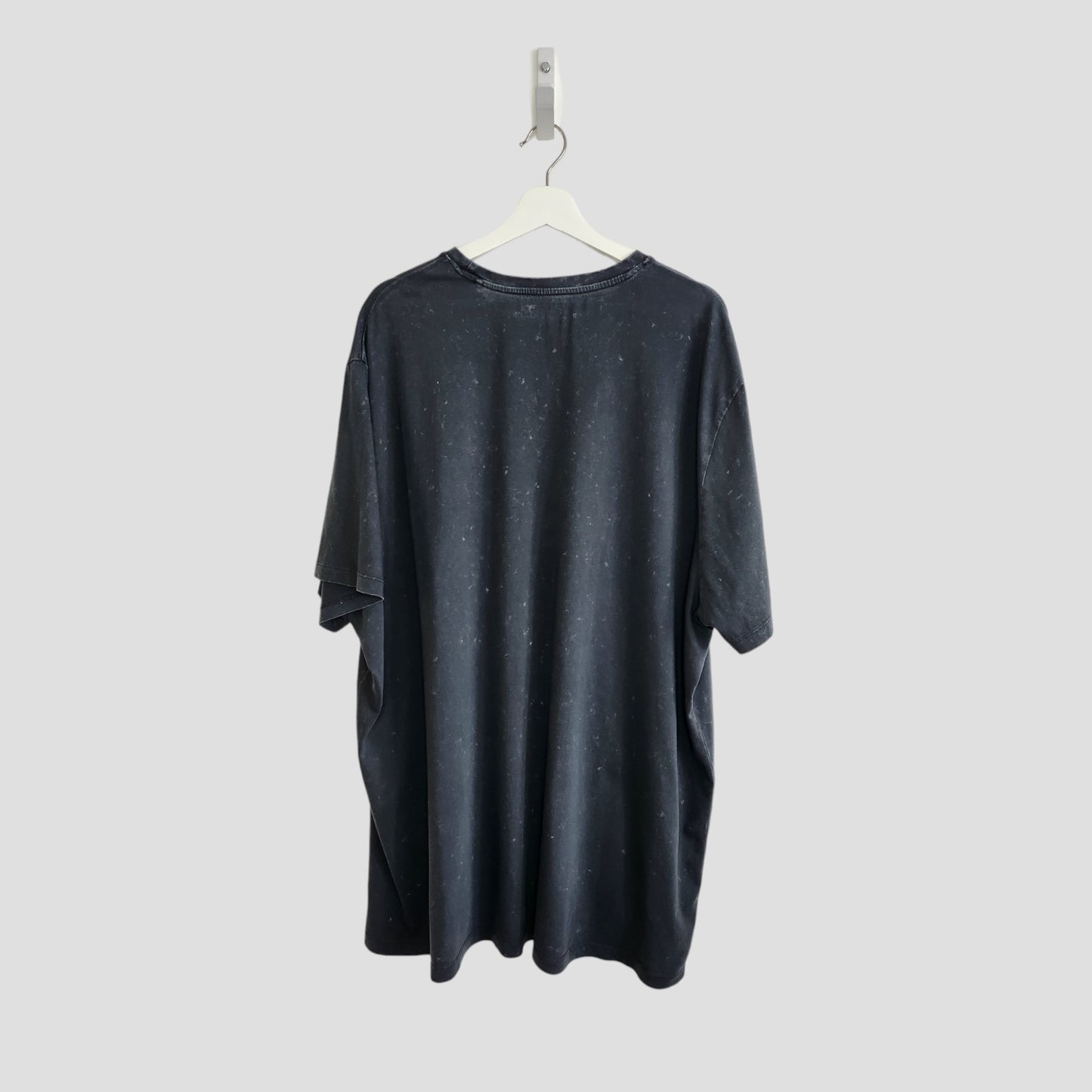 An upcycled The Killers band t-shirt (3XL) for breastfeeding and pumping is shown from the back, hanging on a white hanger against a light grey background. This preloved dark grey shirt features a subtle speckled pattern.