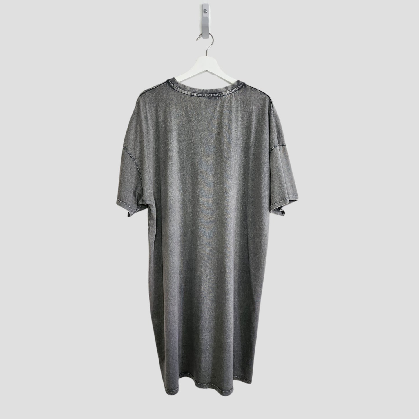 The Primark Upcycled Breastfeeding & Pumping Grey/Pink Nirvana Angel t-shirt dress (L, UK14/16) hangs on a white hanger against a light gray background, shown from the back.