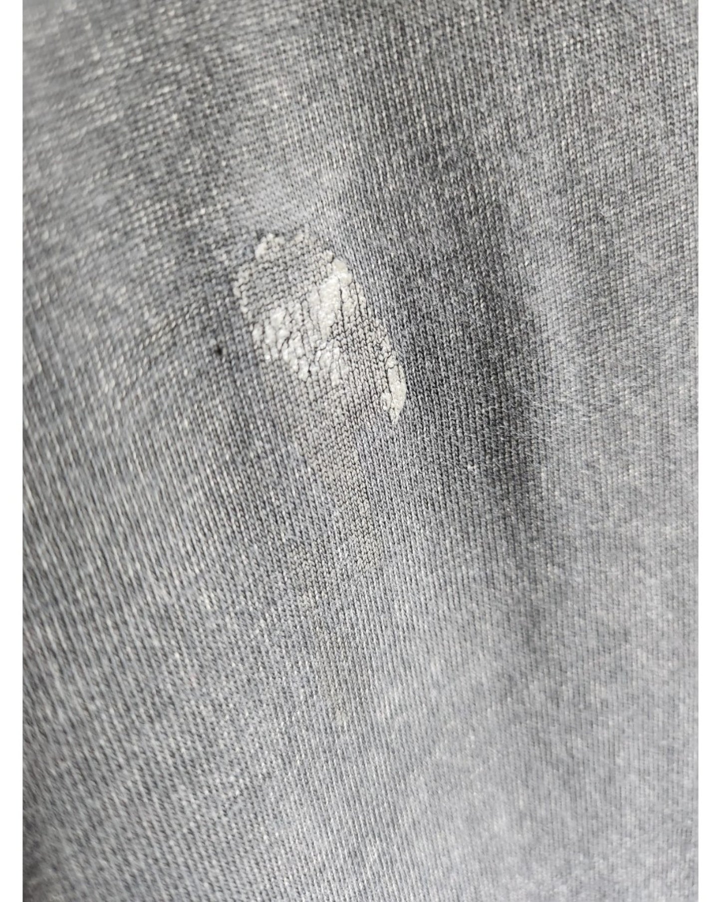 Close-up of a gray Primark Upcycled Breastfeeding & Pumping The Doors Band t-shirt dress (S/UK10-12) fabric, featuring a small worn patch and frayed threads that reflect the unique character of preloved nursing wear.