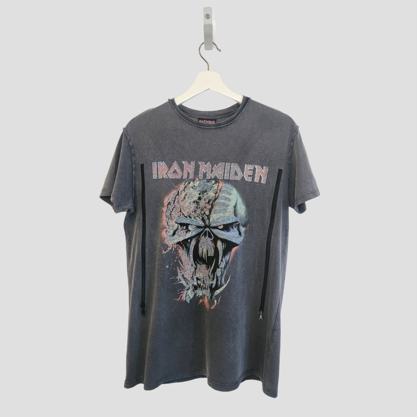 A black Primark upcycled Iron Maiden nursing & pumping t-shirt (UK10, 100234) hangs on a white hanger, showcasing a bold skull graphic and the band’s name—perfect eco-conscious fan wear.