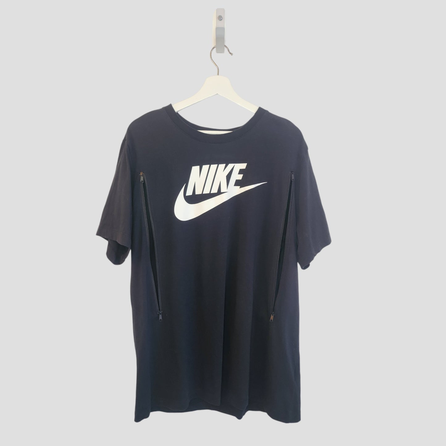 Upcycled Nike Black/White Tick T-shirt XL (100279), preloved and perfect for breastfeeding or pumping—with two vertical chest zippers for stylish, practical access. Bold white logo on front; comes on a white hanger.