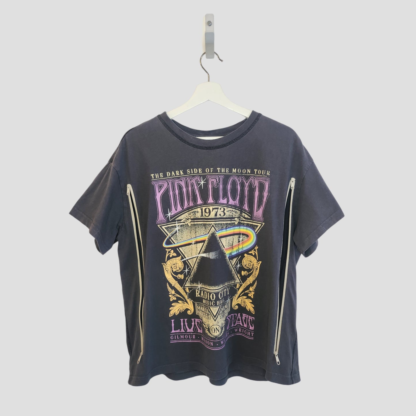 An upcycled grey Pink Floyd Rainbow Band t-shirt by H&M (M, 100256) hangs on a white hanger. This preloved nursing top features long side zippers for easy breastfeeding and stylish comfort.