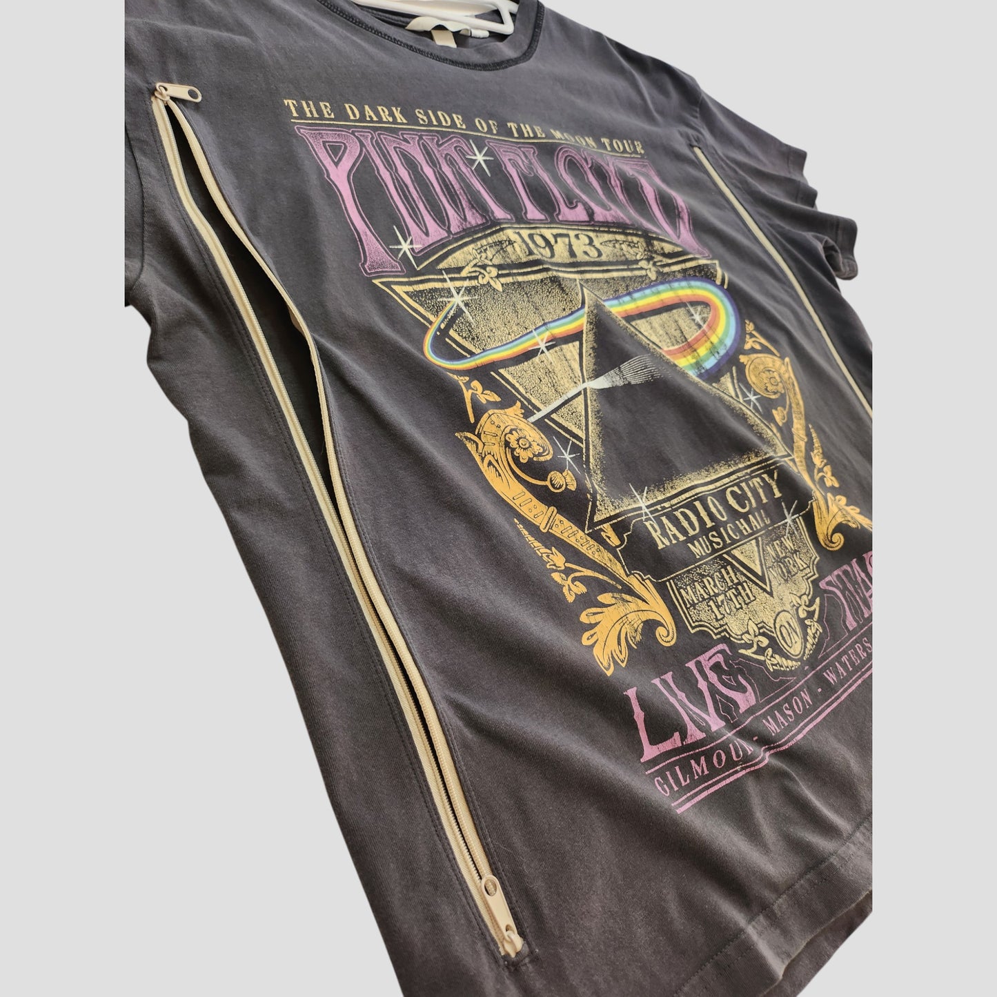 This upcycled H&M Grey Pink Floyd Rainbow Band t-shirt (M) features vibrant Dark Side of the Moon graphics, side zippers for breastfeeding or pumping, and 1973 tour/Radio City Music Hall text.