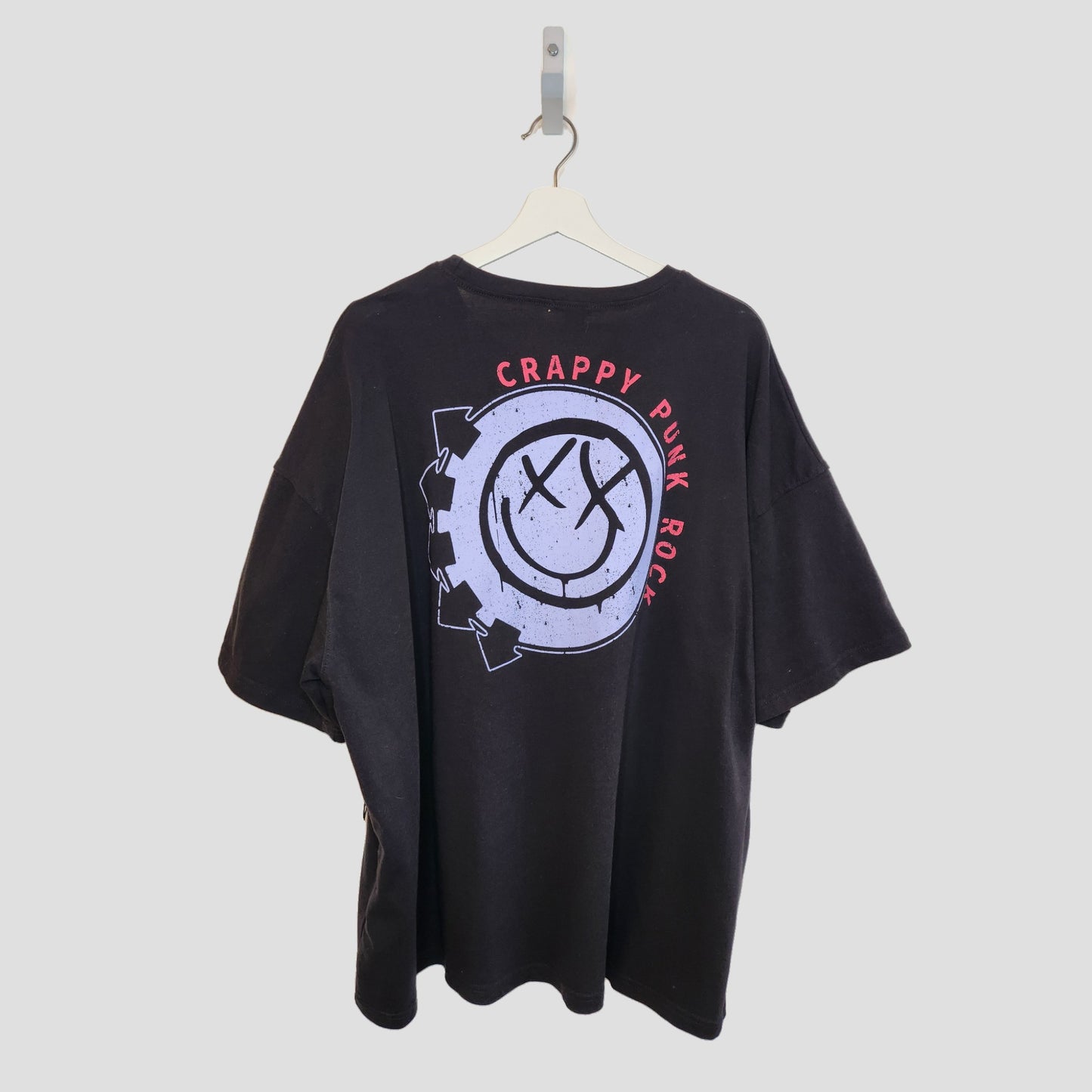 A black upcycled boohoo Blink 182 breastfeeding & pumping T-shirt (UK16, 100294) on a white hanger features a bold back graphic with a distressed smiley face, gears, and CRAPPY PUNK ROCK in red around the design.