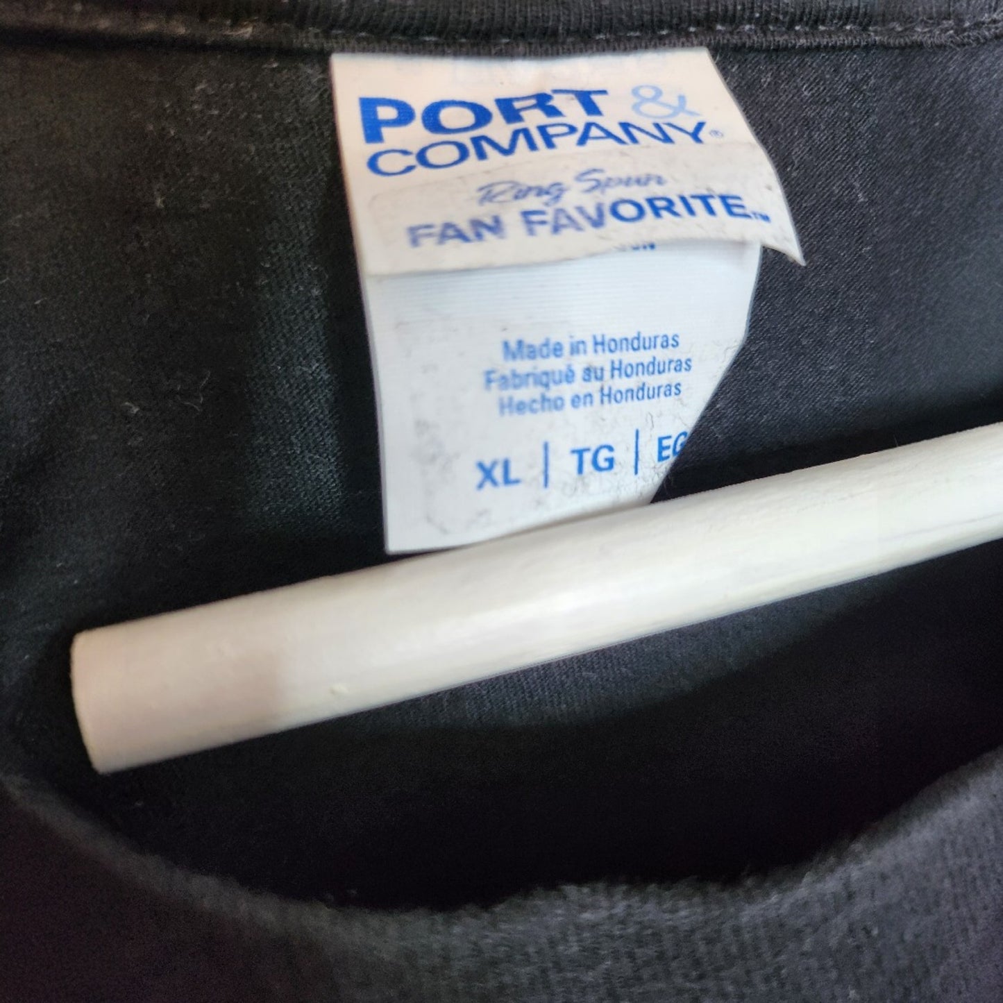 Close-up of a Port & Company clothing tag on an upcycled black Shake It Off t-shirt, size XL. Ideal preloved breastfeeding or pumping top for comfort and style. Product: Upcycled Breastfeeding & Pumping Black Shake It Off t-shirt (100298).