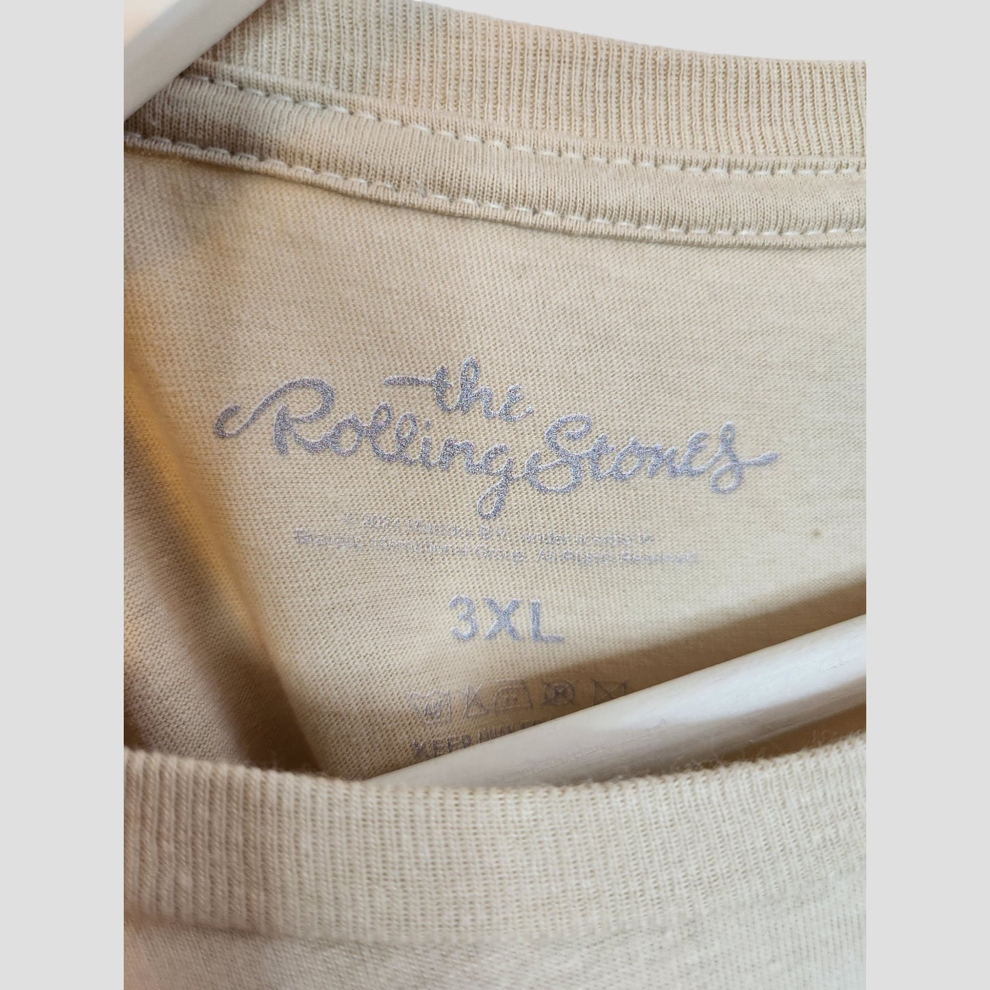 Close-up of the Upcycled Breastfeeding & Pumping Beige Leopard The Rolling Stones T-shirt 3XL, showing the logo printed inside the collar and care symbols. Part of our eco-friendly maternity collection by The Rolling Stones.
