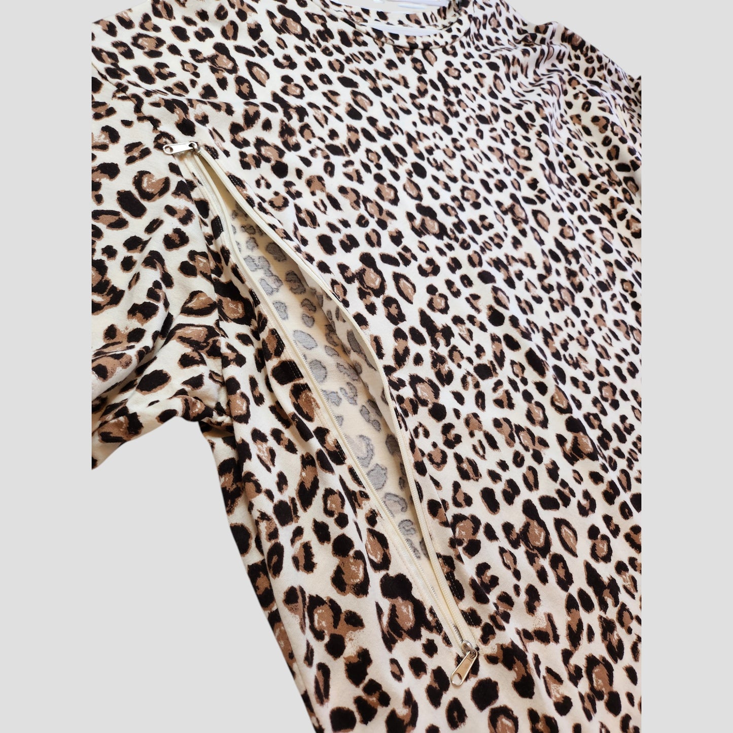 A close-up of the New Look Upcycled Breastfeeding & Pumping Cream Leopard t-shirt UK26 shows a side diagonal zipper revealing the matching animal print lining.