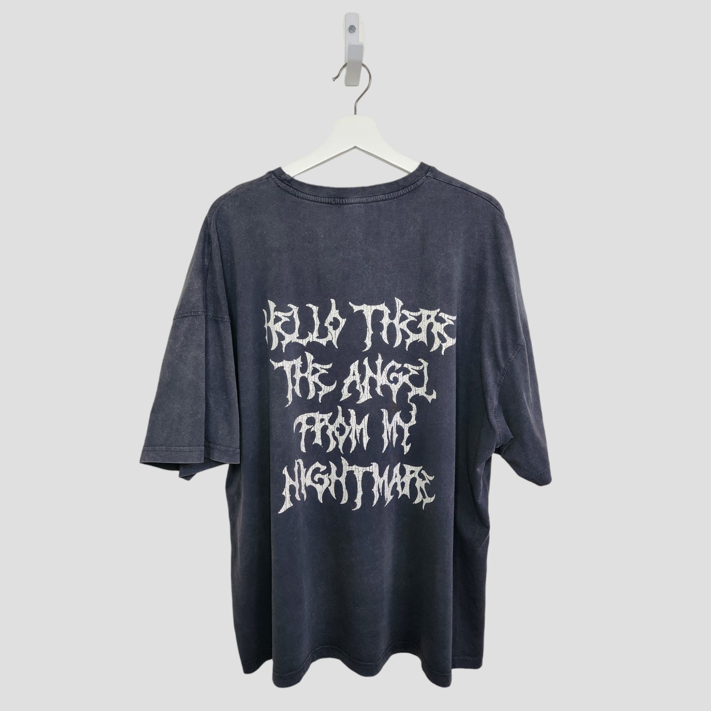The Boohoo Upcycled Breastfeeding & Pumping Blink 182 Band T-shirt (M, 100324) features white stylized "HELLO THERE THE ANGEL FROM MY NIGHTMARE" text on the back, shown on a hanger against a plain light background.