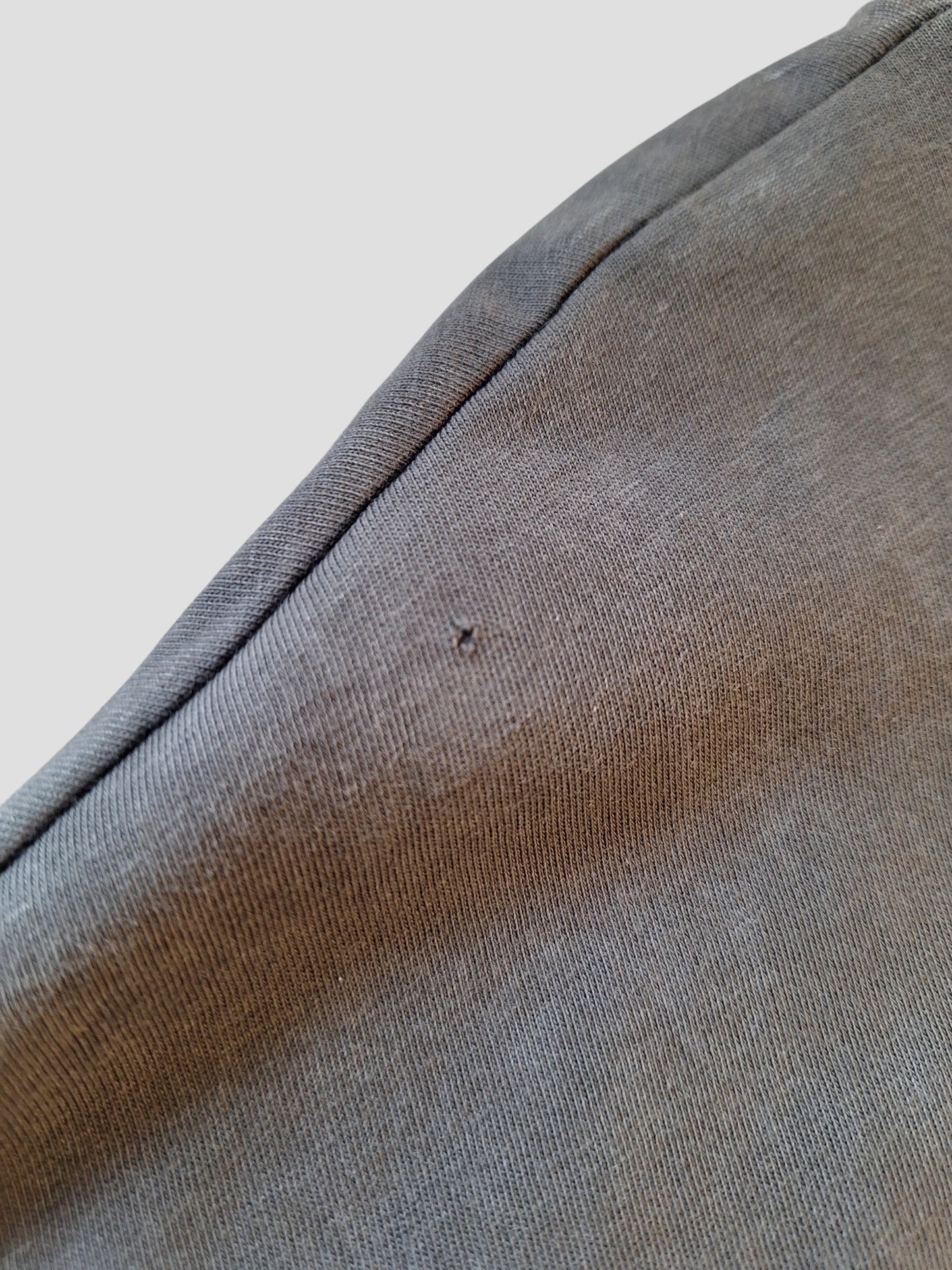 A close-up of the Nutmeg Upcycled Breastfeeding & Pumping Grey Blondie Band t-shirt UK20 (100361) shows a small hole near the seam, highlighting the textured gray fabric and careful stitching.