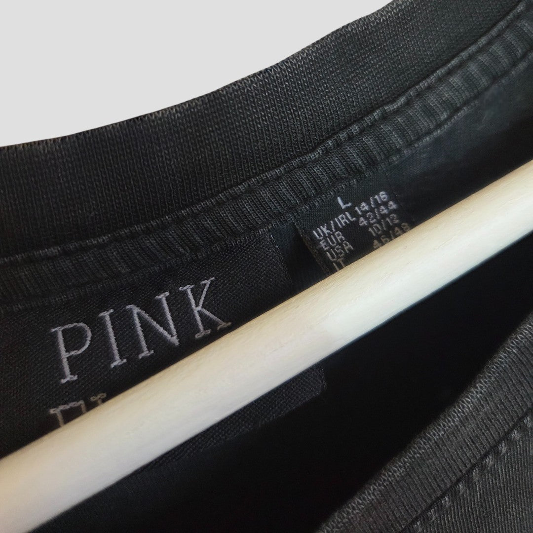 Close-up of the inside label of a black Primark garment on a hanger, showing brand and size tags—ideal for those seeking affordable upcycled breastfeeding & pumping wear like this Pink Floyd band t-shirt dress (UK14/16).