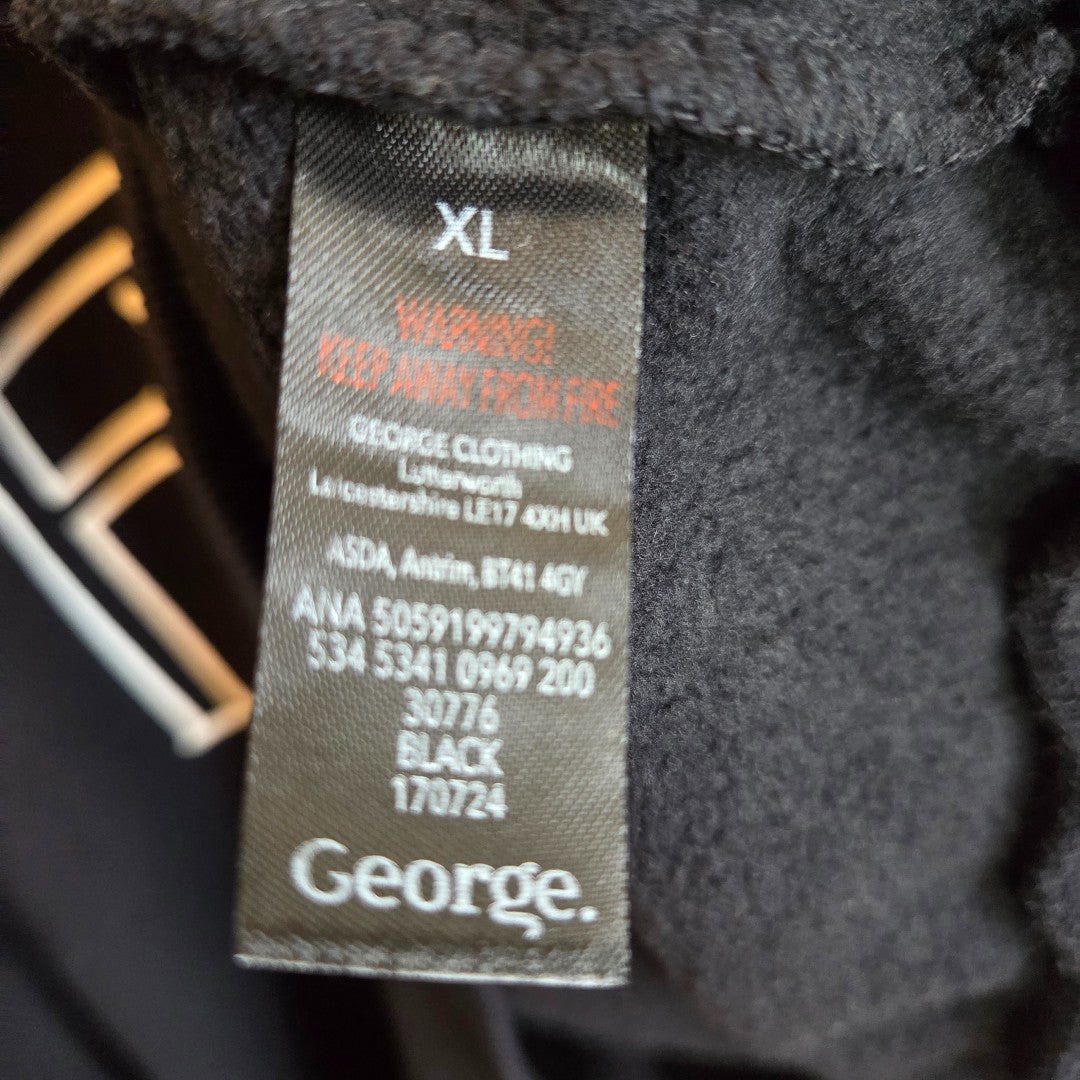 A close-up of a black clothing label inside an XL upcycled George breastfeeding & pumping Fleetwood Mac band sweatshirt. The label reads XL, WARNING! KEEP AWAY FROM FIRE, includes manufacturer details, care codes, and the George brand.