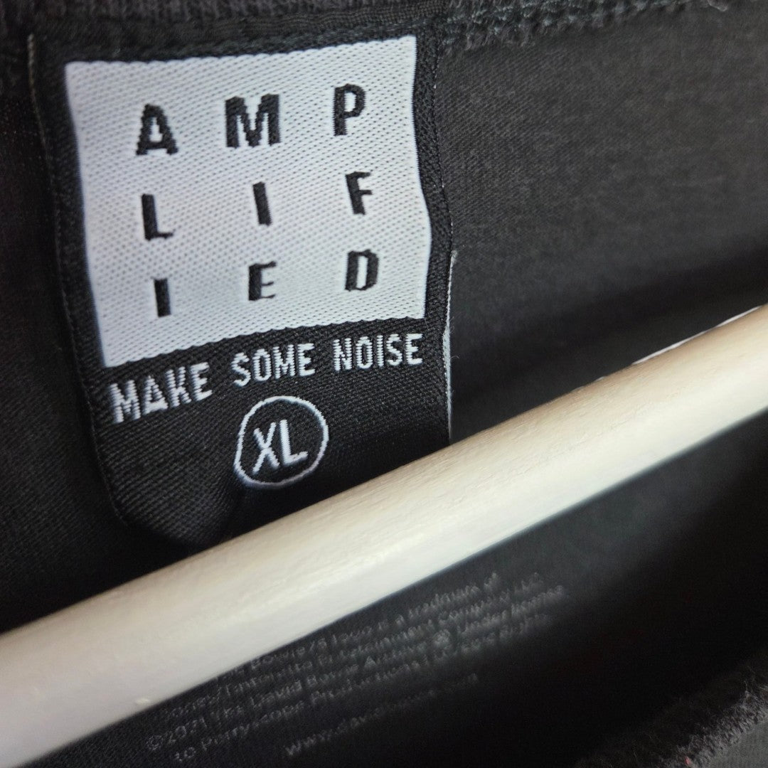 An eco-friendly upcycled Amplified t-shirt in grey/burgundy (XL, style 100425) features a black label with bold white “AMPLIFIED,” “MAKE SOME NOISE,” and XL circled, hanging on a light-colored wooden hanger.
