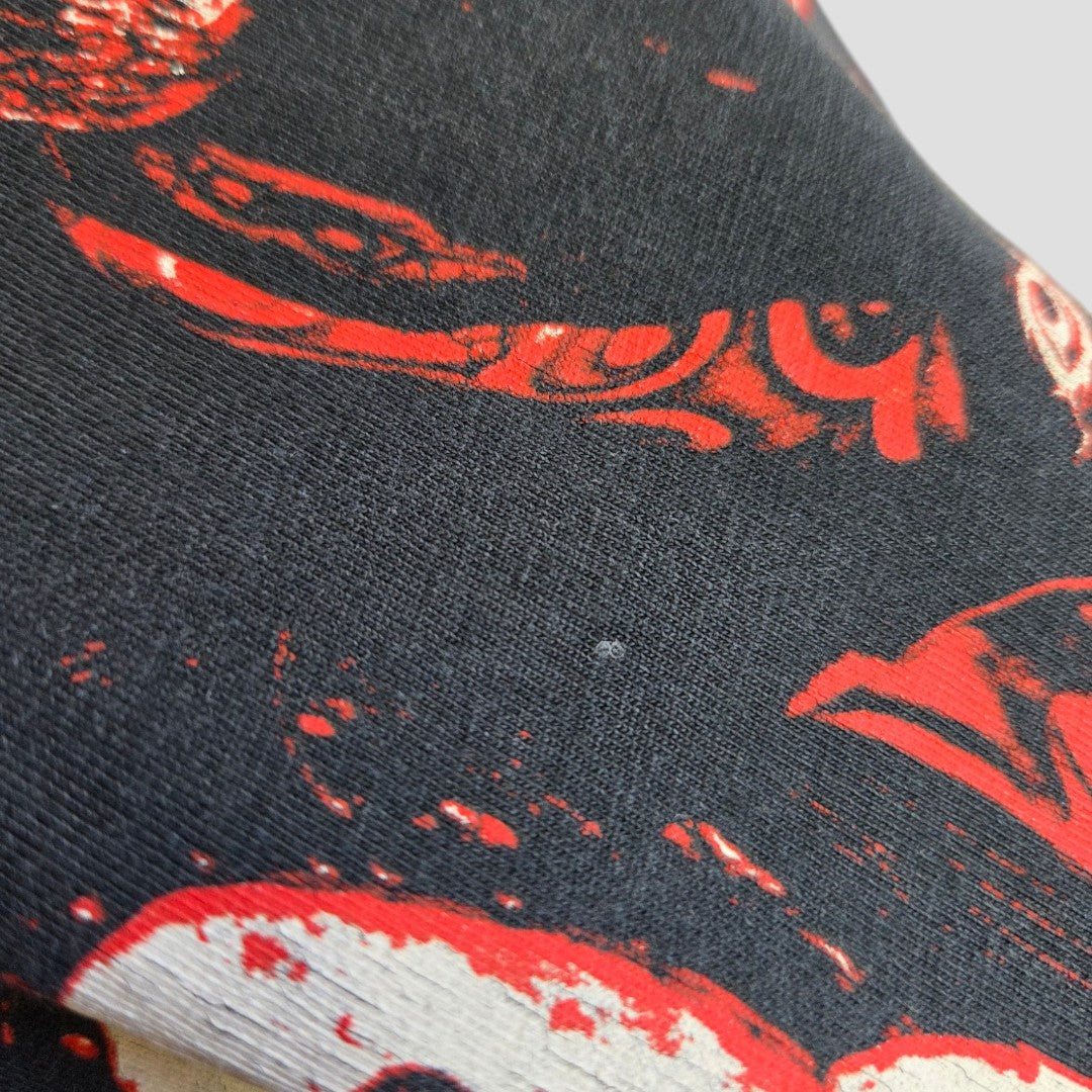 Close-up of black fabric with red and white abstract patterns, from a Primark Upcycled Breastfeeding & Pumping Slipknot Band t-shirt (2XL, grey/red, 100456).
