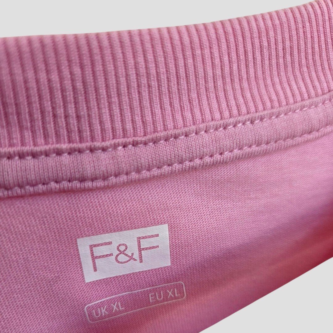 Close-up of a pink Upcycled Breastfeeding & Pumping Ibiza t-shirt (F&F, XL) with ribbed neckline, visible stitching, and inside tag. Part of F&F’s affordable maternity wear.