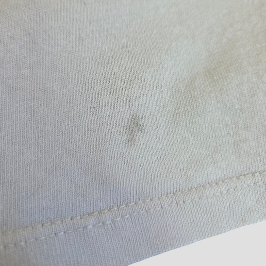 Close-up of H&M's Upcycled Breastfeeding & Pumping Beige/Pink The Who Band t-shirt (L, 100450) showing a faint small dark stain by the seam and slight discoloration on the eco-friendly material.