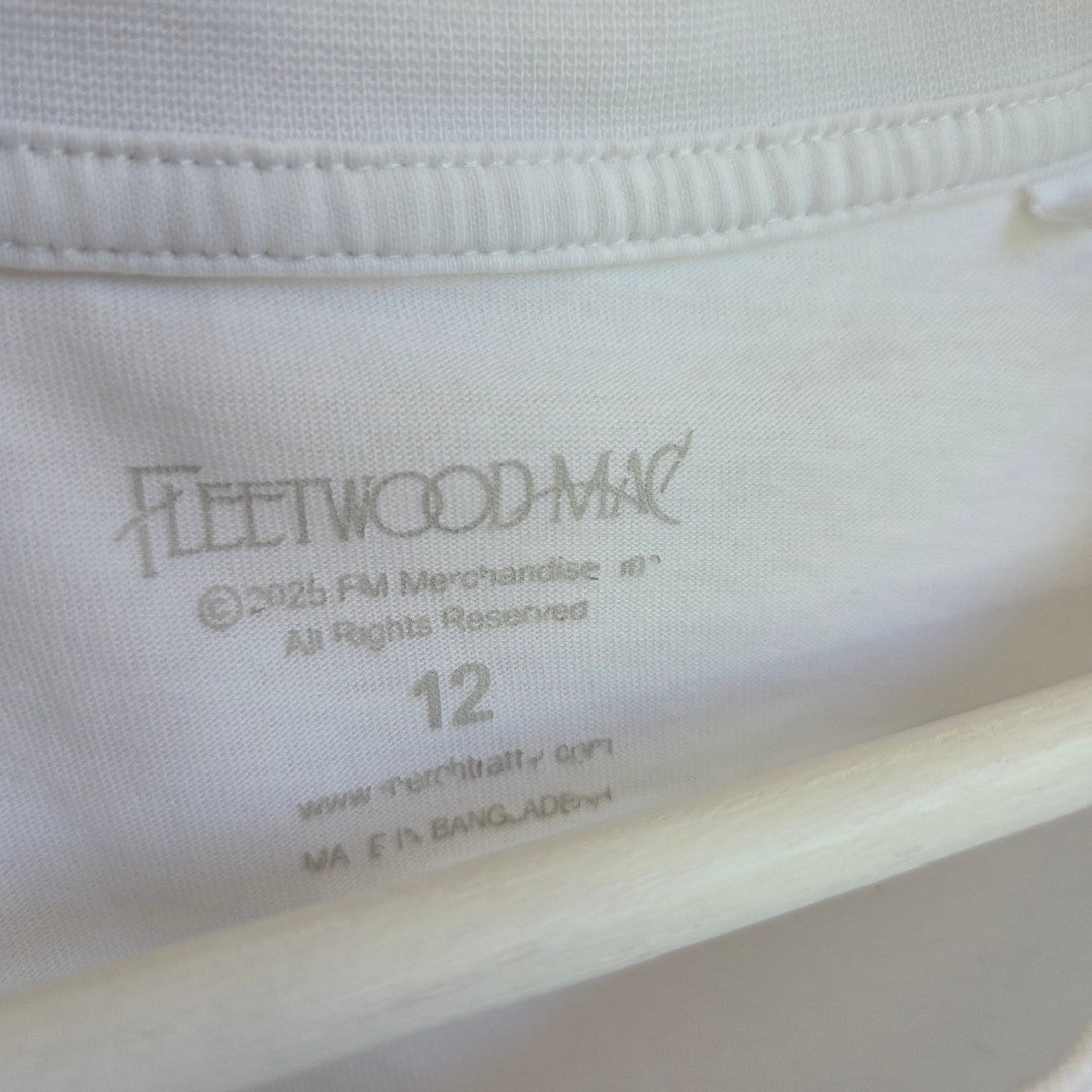 Close-up of a white clothing tag inside a Tu Upcycled Breastfeeding & Pumping Fleetwood Mac Floral Band t-shirt (UK12), showing size, brand, and other details printed in gray.