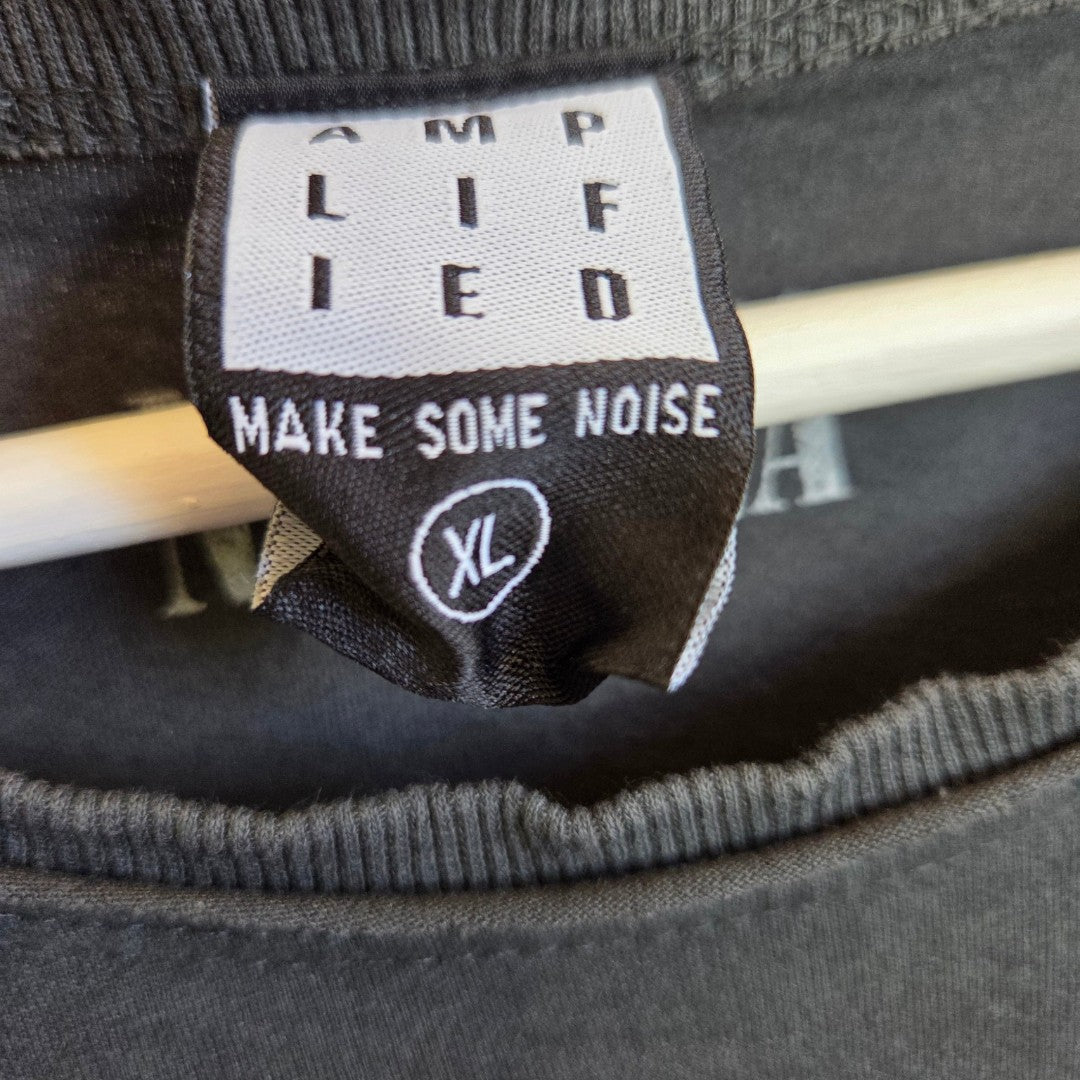 A close-up of a black Amplified tag reading "AMPLIFIED, MAKE SOME NOISE, XL" on the Upcycled Breastfeeding & Pumping Grey Nirvana Serpent Band t-shirt XL (100483), shown on a light hanger—ideal eco-friendly style for nursing moms.