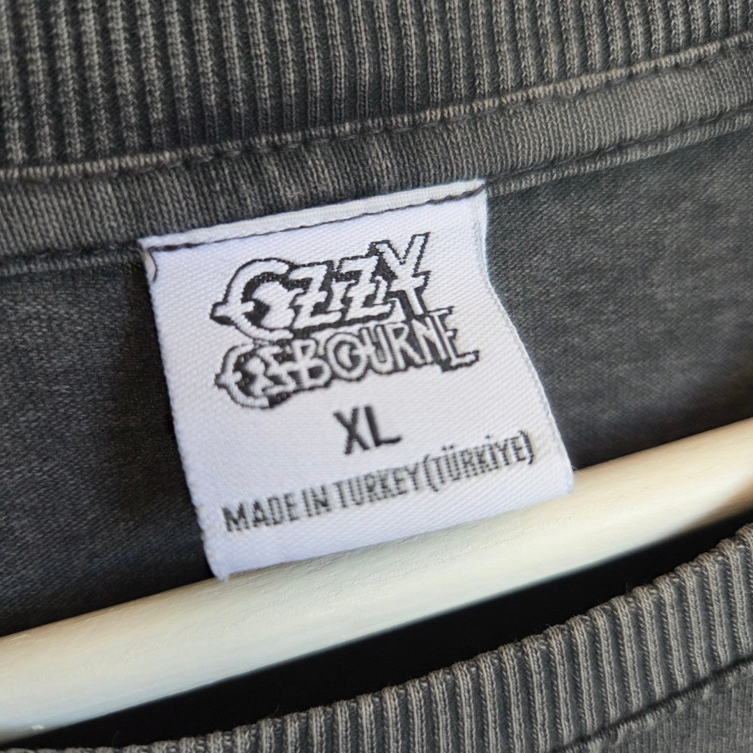 A close-up of a Primark tag on an upcycled grey Ozzy Osbourne XL nursing and pumping band t-shirt (100502), made in Turkey, hanging on a hanger.