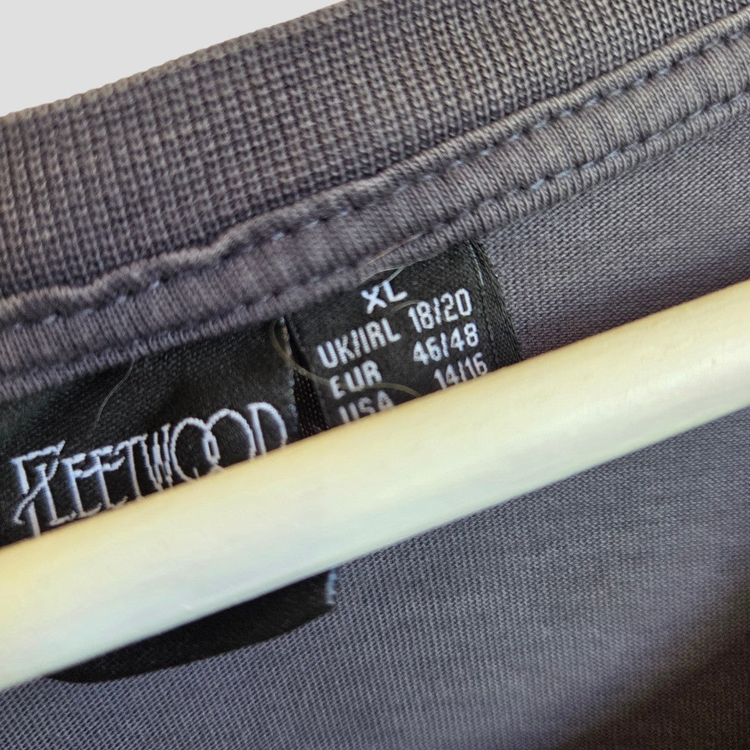 A close-up of a Primark Upcycled Breastfeeding & Pumping Floral Fleetwood Mac Band t-shirt (XL, UK18/20) on a hanger, showing the size label and partially visible "FLEETWOOD" text.