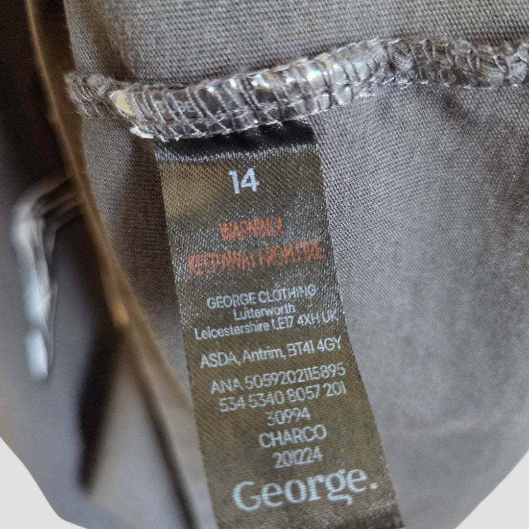 Close-up of a black label with white and orange text on the George Upcycled Breastfeeding & Pumping Grey Iron Maiden Band t-shirt UK14, showing size, care info, and branding—perfect for eco-friendly or nursing wear.