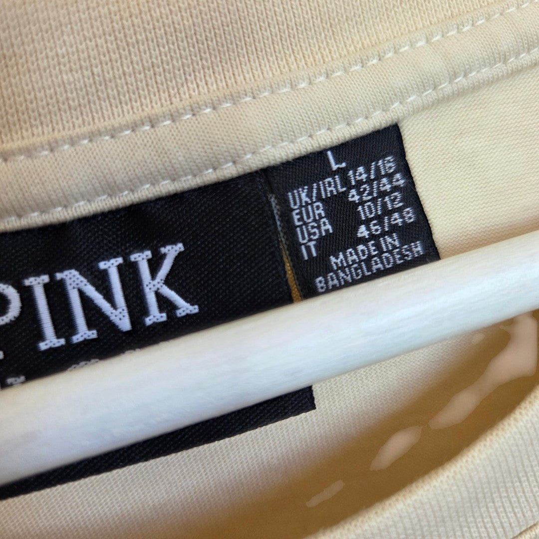 A close-up of a Primark label on an upcycled cream Pink Floyd band nursing & pumping t-shirt (L/UK14/16), made in Bangladesh, with the adjacent tag partially showing "PINK.