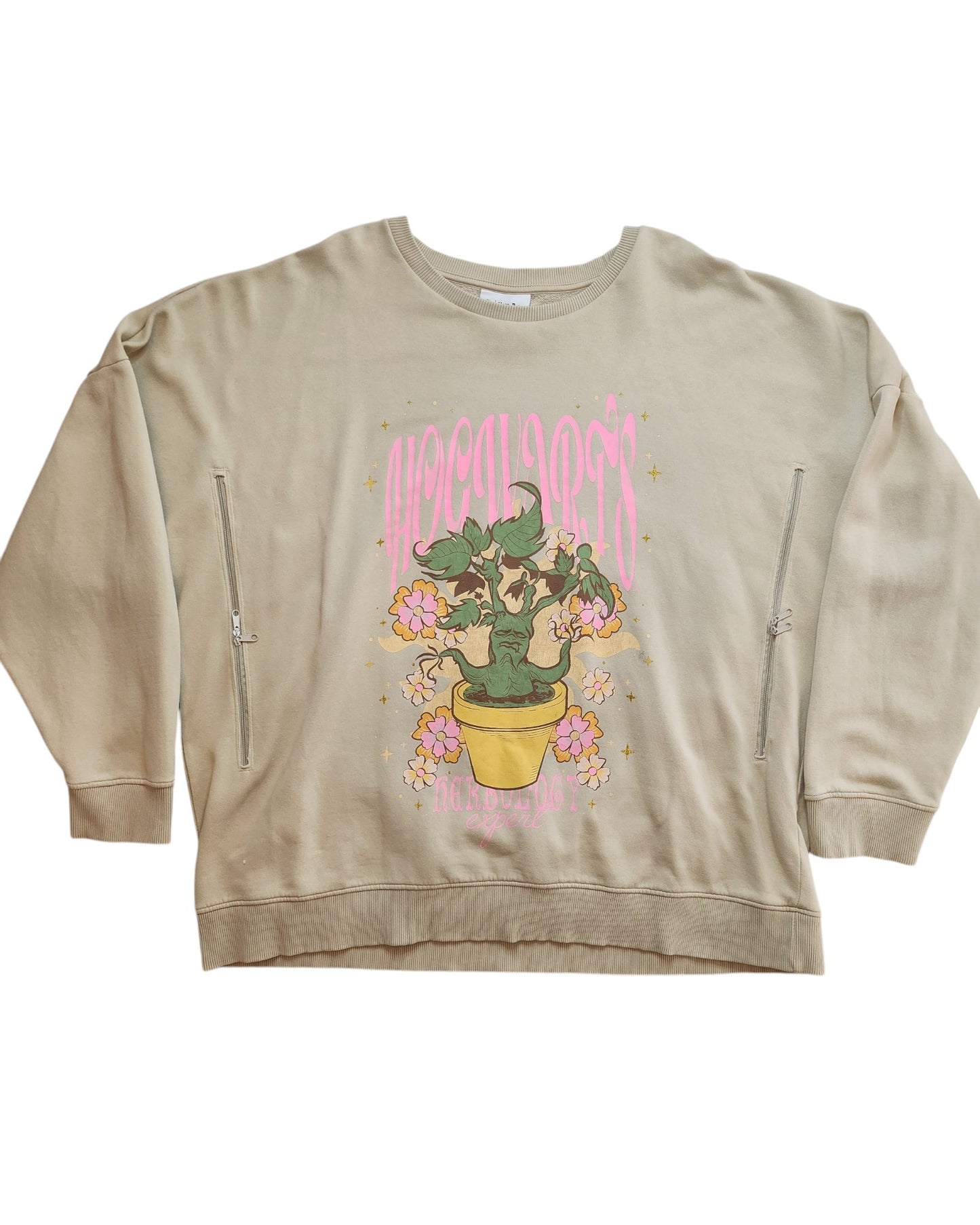 The Upcycled Breastfeeding & Pumping Harry Potter Sweatshirt 2XL from touched out mama is a beige top with a potted green plant and pink flowers, encircled by the word Apocalypse in pink text and star accents. Made from preloved clothing, it includes two zippers for easy nursing access.