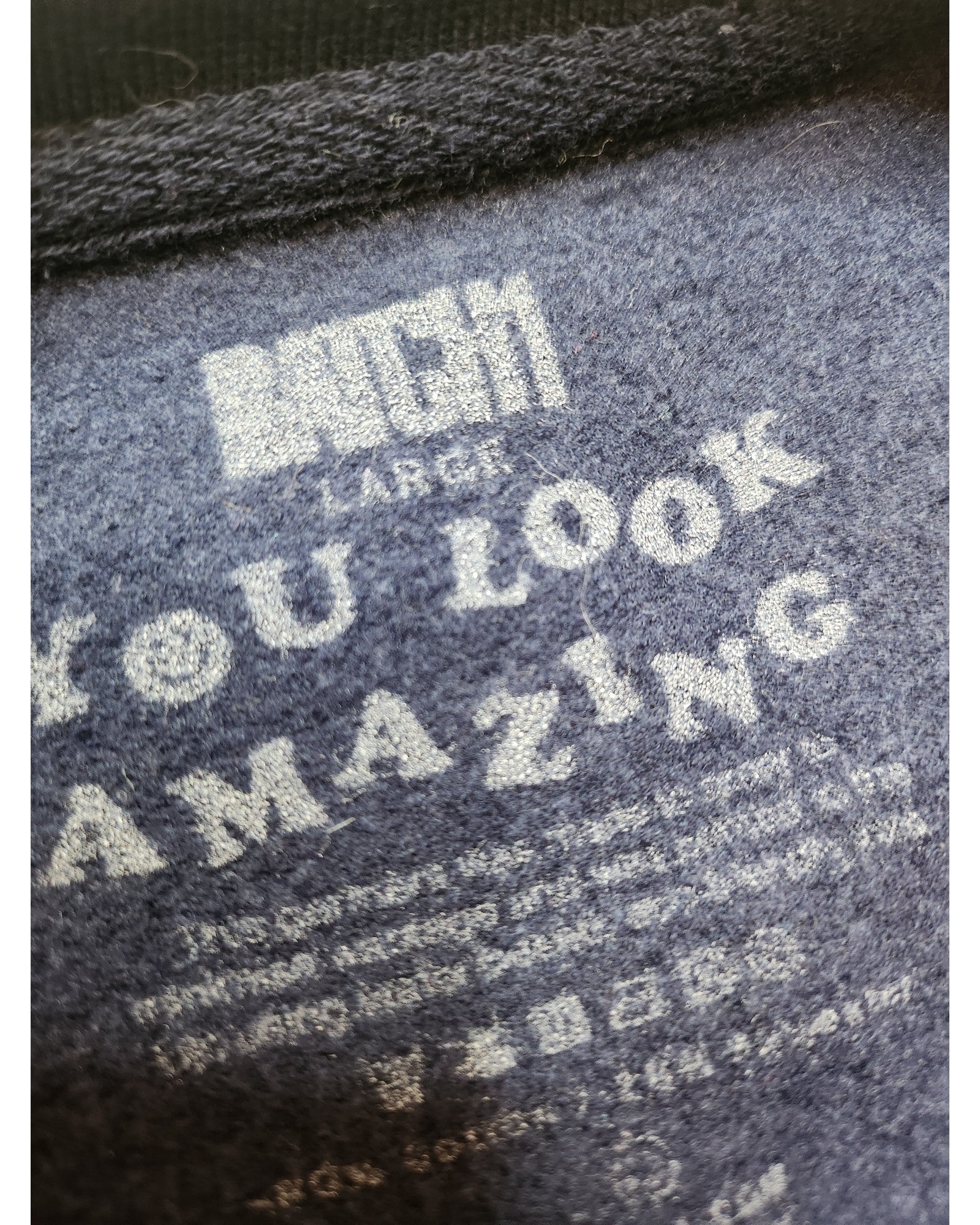 Close-up of preloved dark fabric with white text. Main text reads YOU LOOK AMAZING, with care and size info below, highlighting the beauty of the Upcycled Breastfeeding & Pumping Rainbow Sweatshirt L by touched out mama.