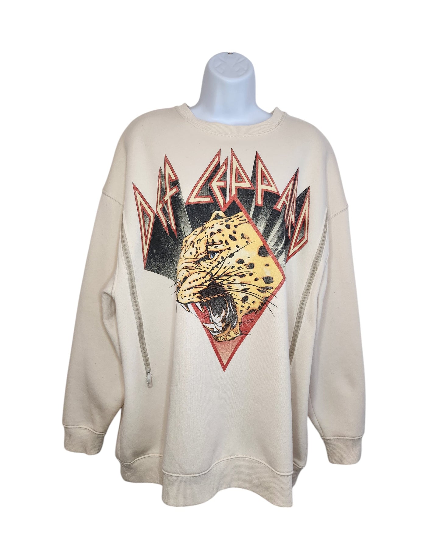 The Upcycled Breastfeeding & Pumping Def Leppard Cream Sweatshirt by touched out mama is a striking eco-friendly piece, featuring a roaring leopard illustration with stylized text and geometric accents in red, black, and yellow for wild flair.
