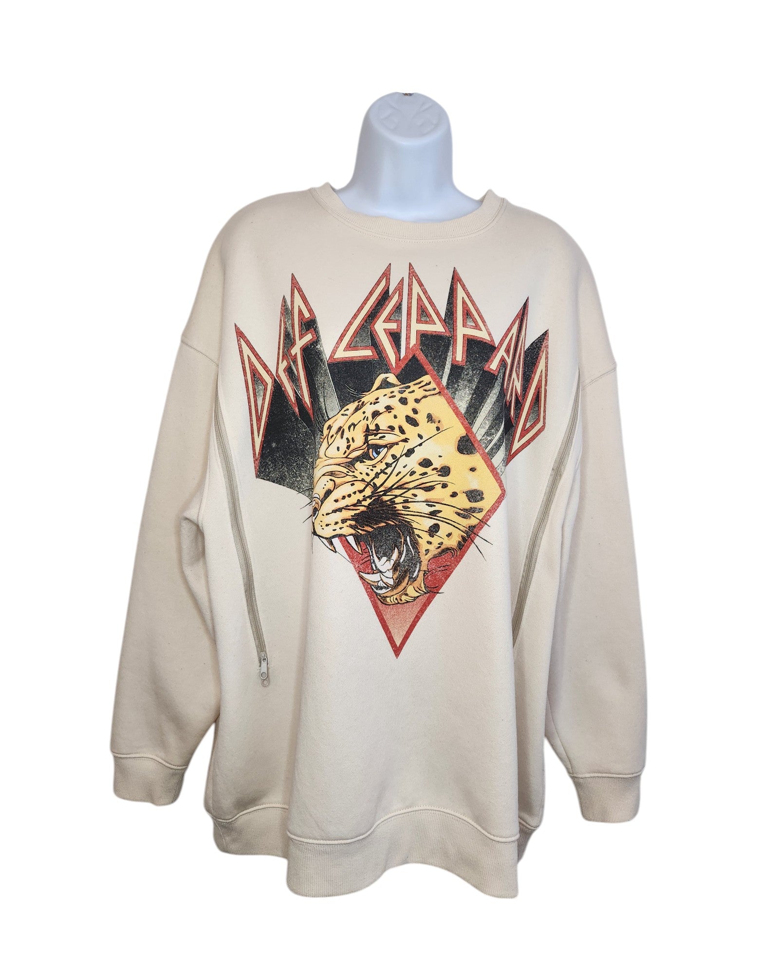 The Upcycled Breastfeeding & Pumping Def Leppard Cream Sweatshirt by touched out mama is a striking eco-friendly piece, featuring a roaring leopard illustration with stylized text and geometric accents in red, black, and yellow for wild flair.