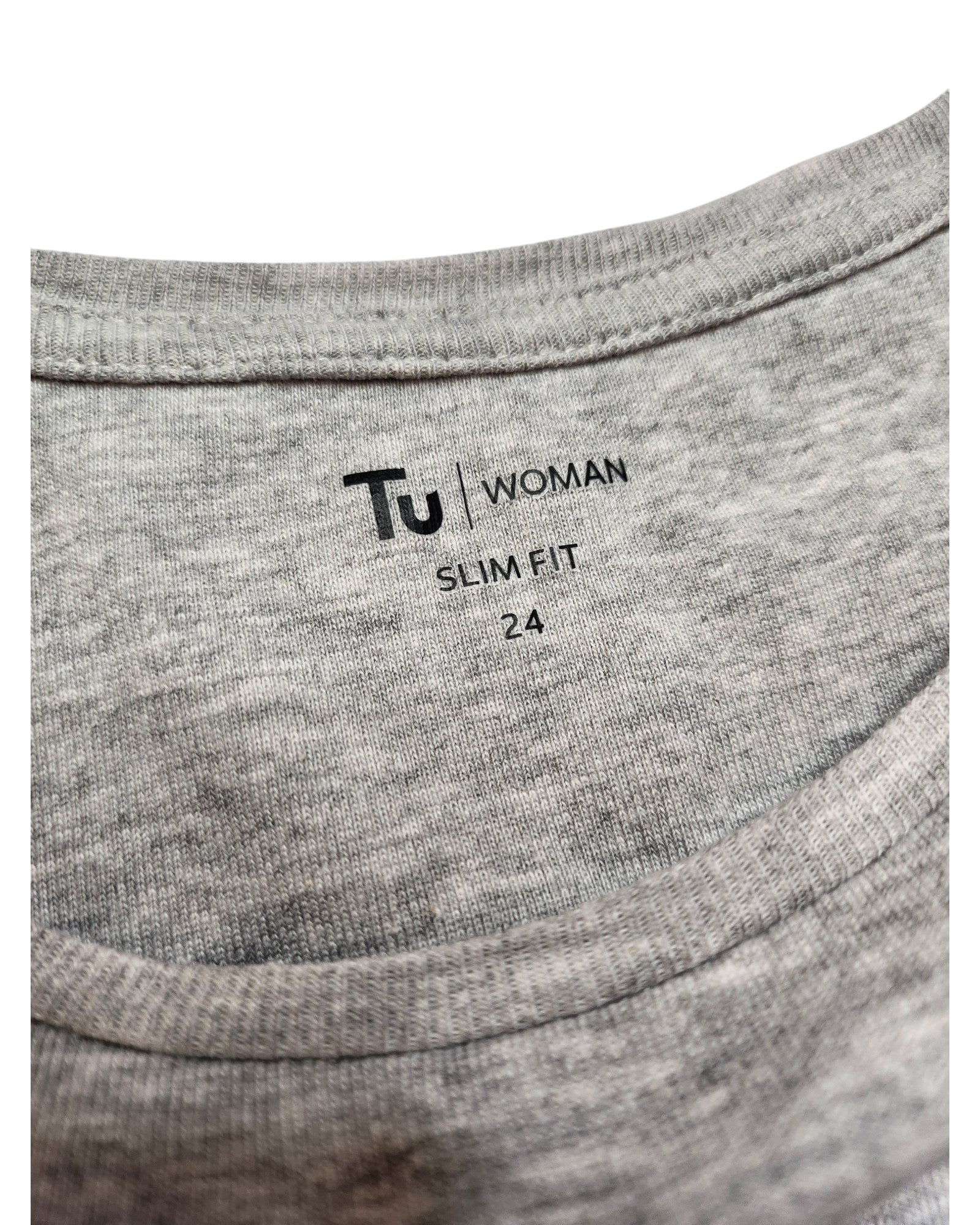 Close-up of a gray T-shirt label displaying touched out mama, featuring the text UK24 for size, and accentuating its preloved charm with fabric texture visible. The shirts name is Upcycled Breastfeeding (Nursing) & Pumping Grey Floral Zips t-shirt, laid flat with label printed directly on material.