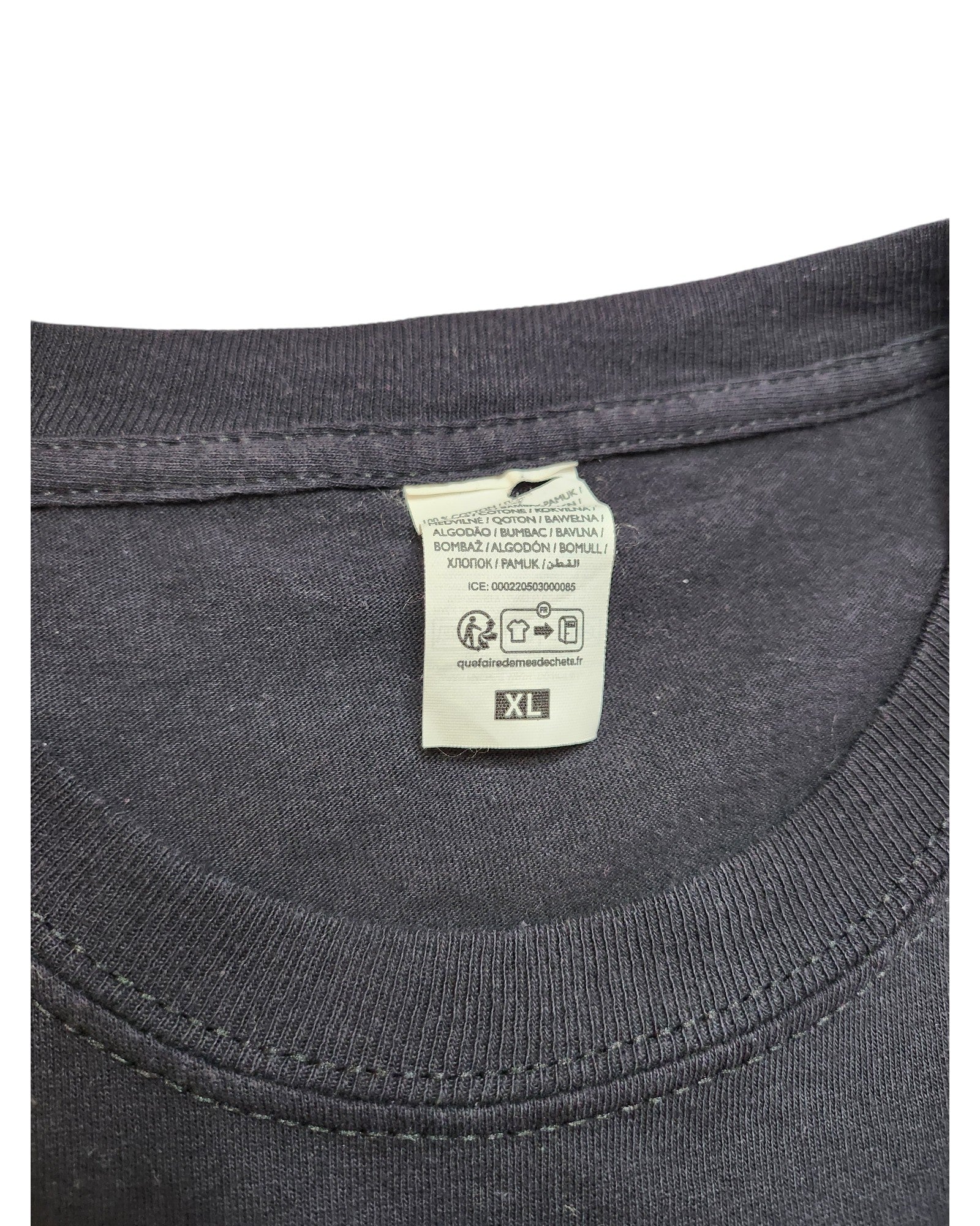 Close-up of the Upcycled Breastfeeding & Pumping Nirvana t-shirt XL by touched out mama, showing a black collar with a sewn-in label detailing care instructions and size XL in multiple languages, perfect for preloved clothing enthusiasts.