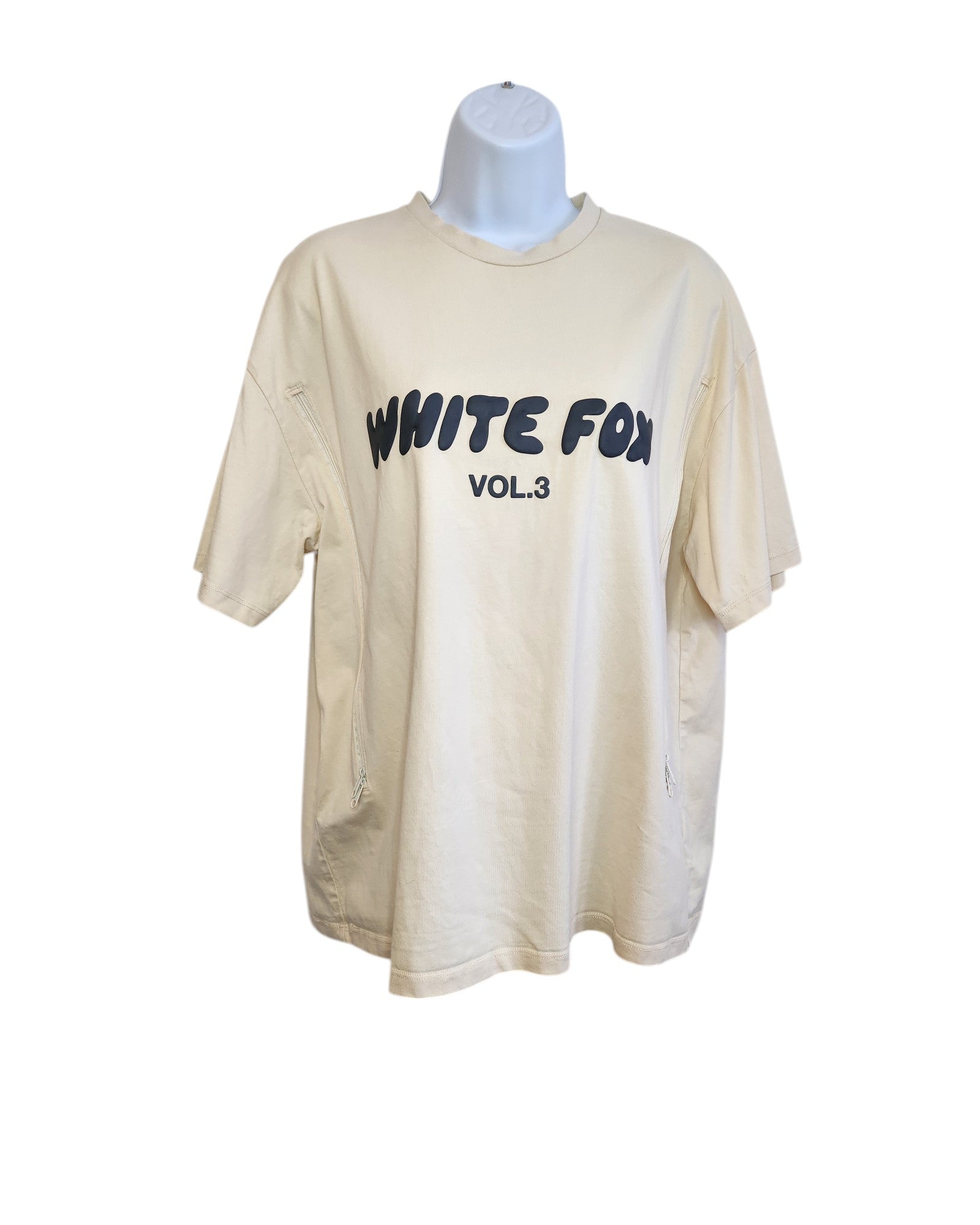 On a display stand, the Upcycled Breastfeeding & Pumping White Fox Cream T-shirt by touched out mama features bold black WHITE FOX VOL.3 text on the front, short sleeves, and a minimalist design that harmonizes sustainability and style without extra patterns or decorations.