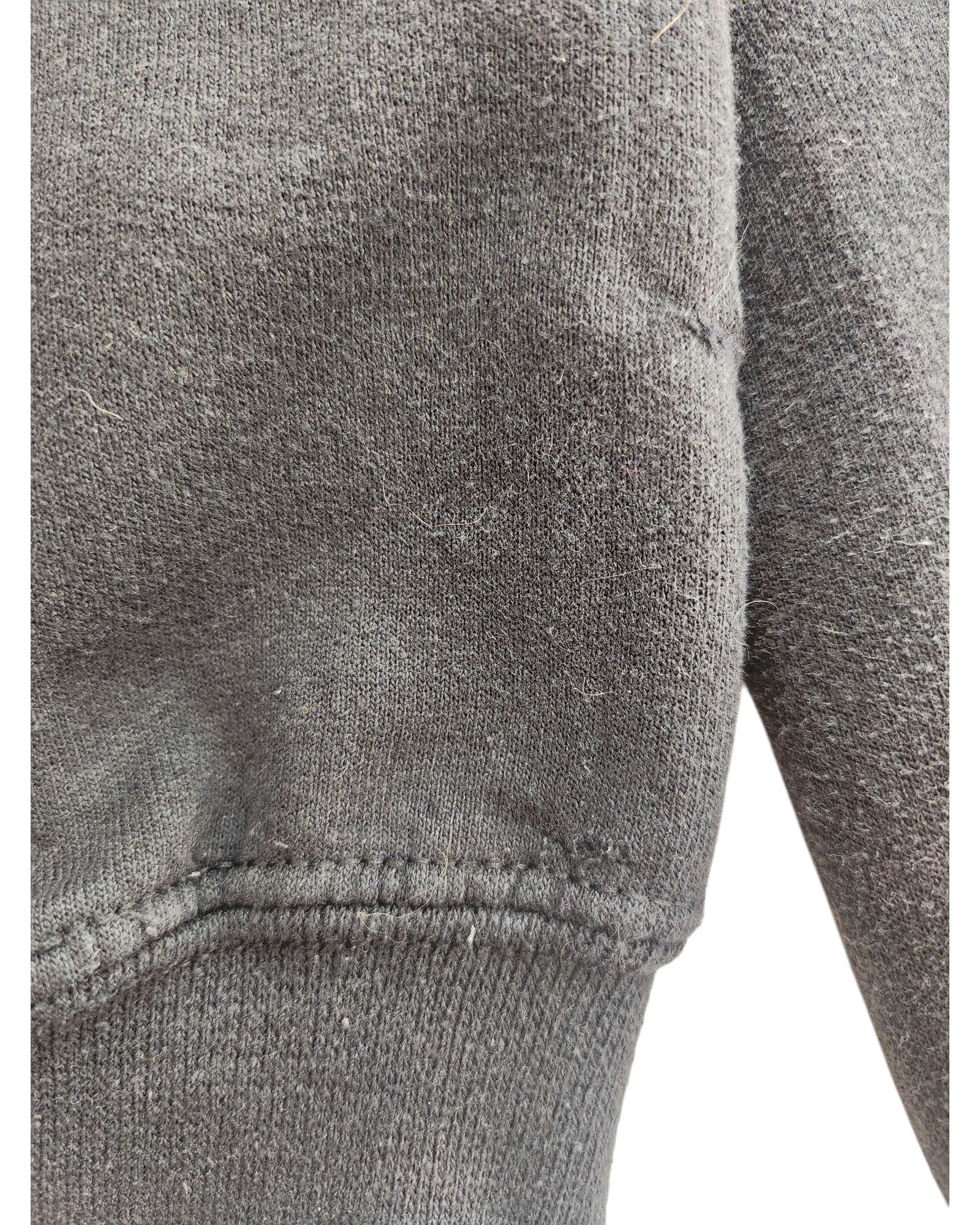 The close-up of the Upcycled Breastfeeding & Pumping Little Mix Hoodie L by touched out mama features a dark gray knitted fabric with visible seam detailing. This eco-friendly piece highlights sustainable fashion through its responsibly sourced materials and intricate weave texture.