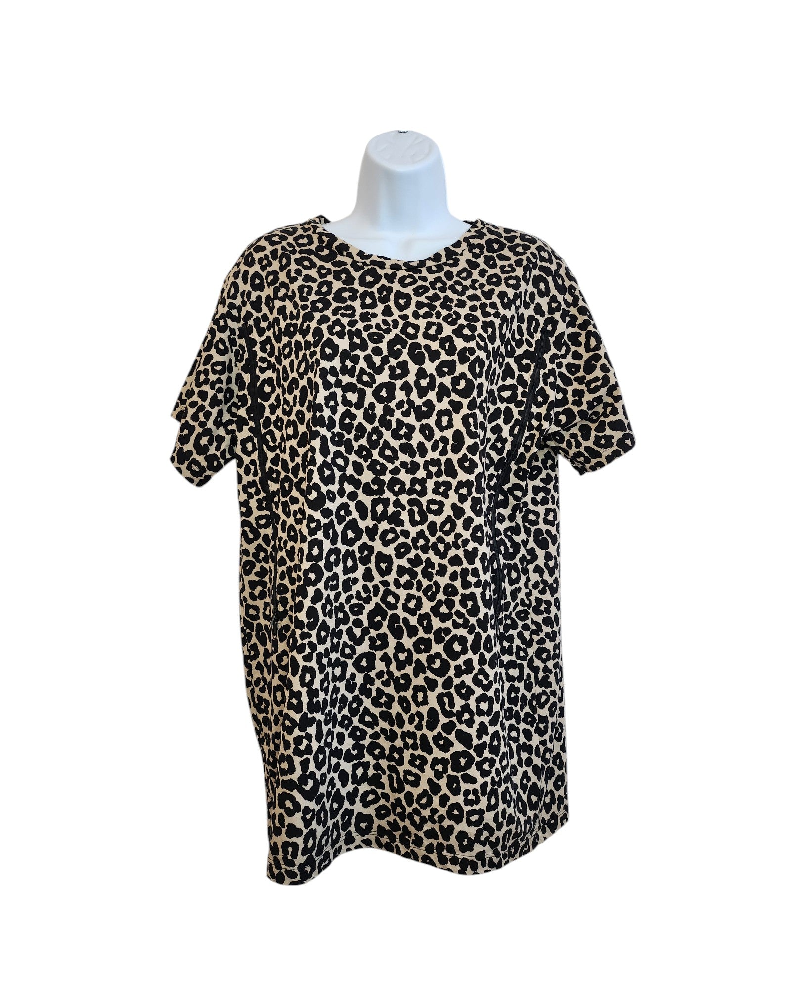 A chic and eco-friendly piece, the Upcycled Breastfeeding (Nursing) & Pumping Leopard T-shirt by touched out mama is a short-sleeved, loose-fit top made from upcycled clothing. It features a round neckline and leopard print with beige and black spots, showcased stylishly on a mannequin.