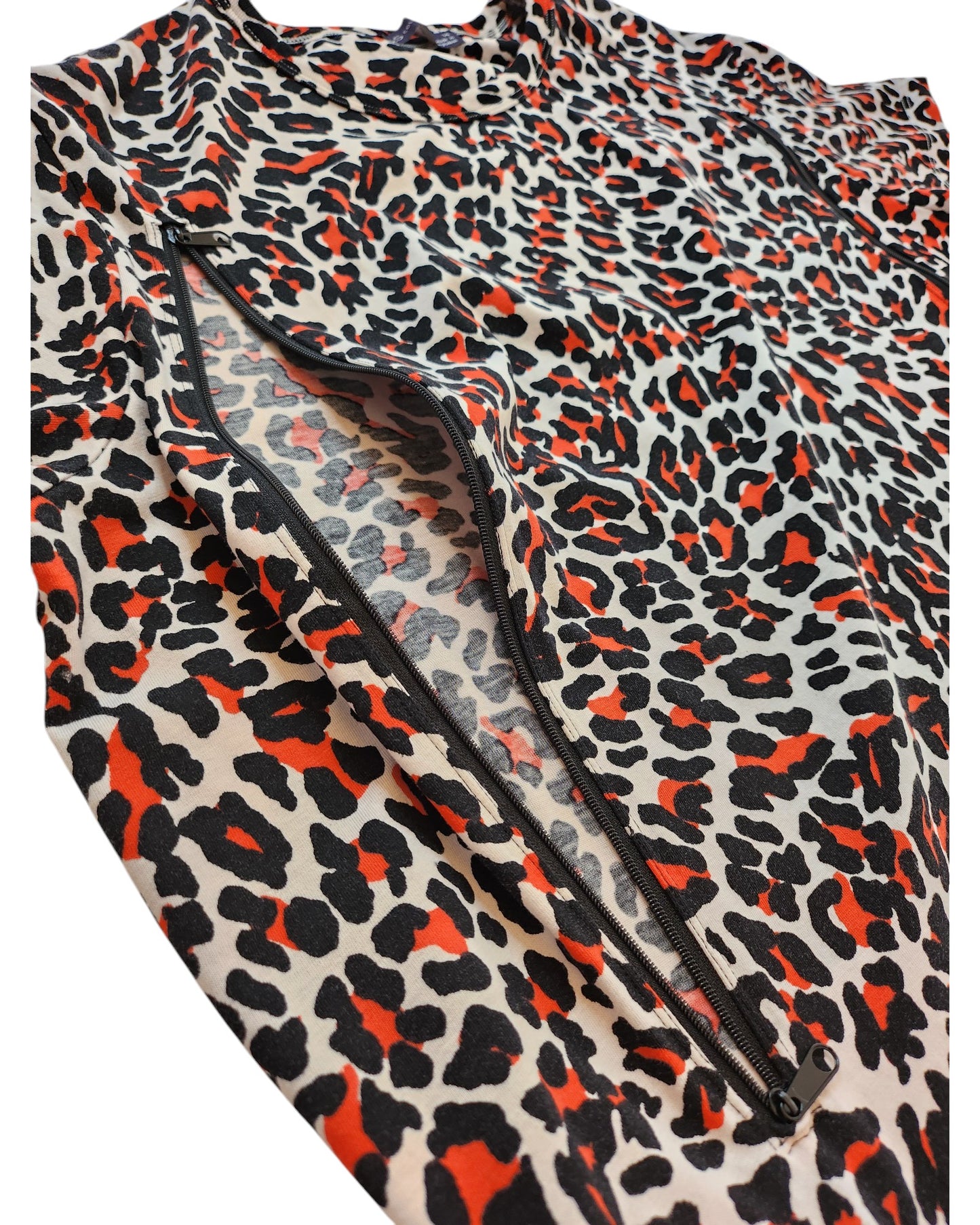 Close-up of a textured, upcycled fabric with a bold leopard print in black, orange, and white from the Upcycled Breastfeeding & Pumping Leopard Pocket T-shirt Dress UK14 by touched out mama, featuring a visible zipper seam.