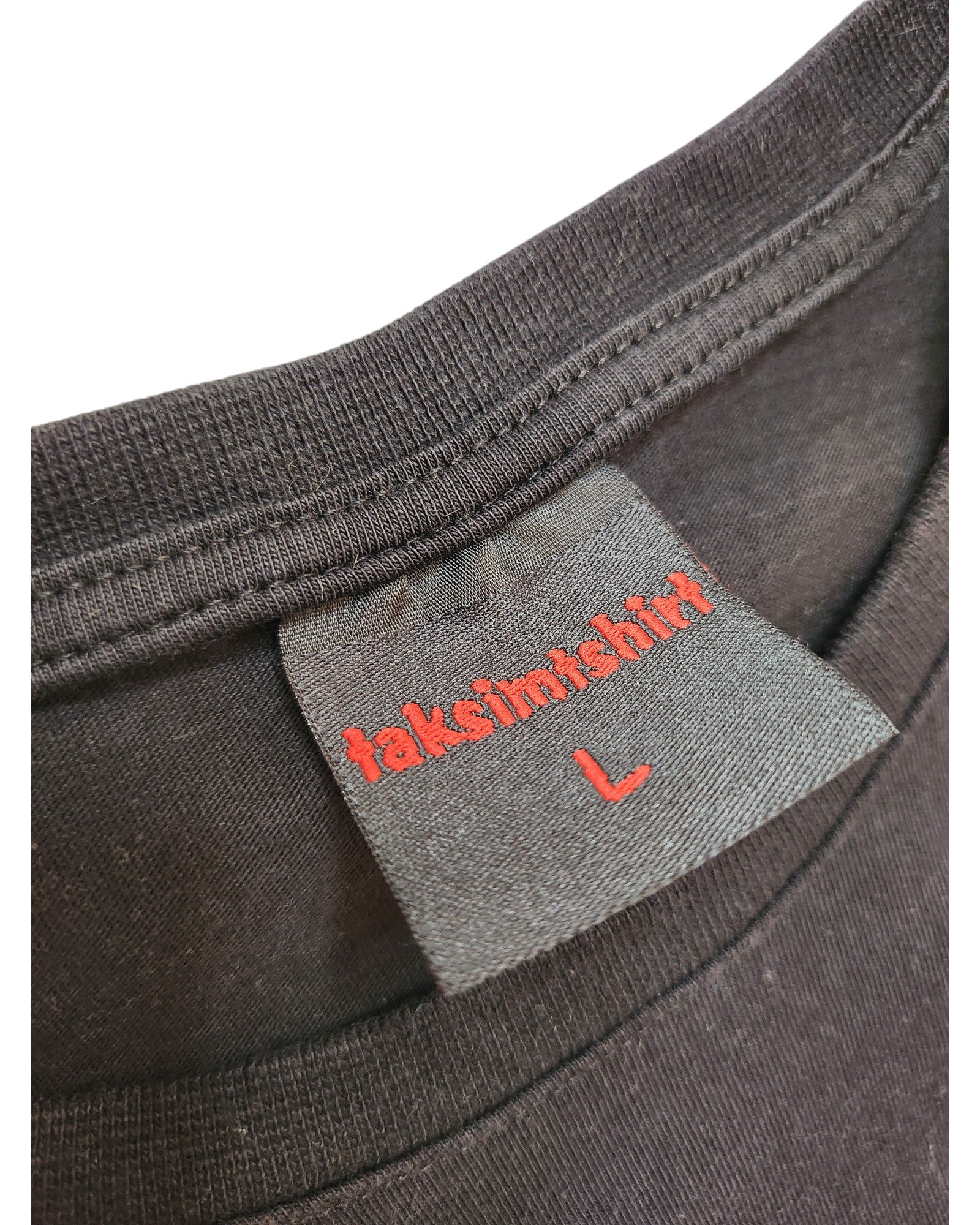 Close-up of a black T-shirt neckline reveals an upcycled style. The label, reflecting the brand touched out mama, shows red text takshinshtirt and a red L, embracing affordable eco fashion with their Slipknot nursing and pumping tee.