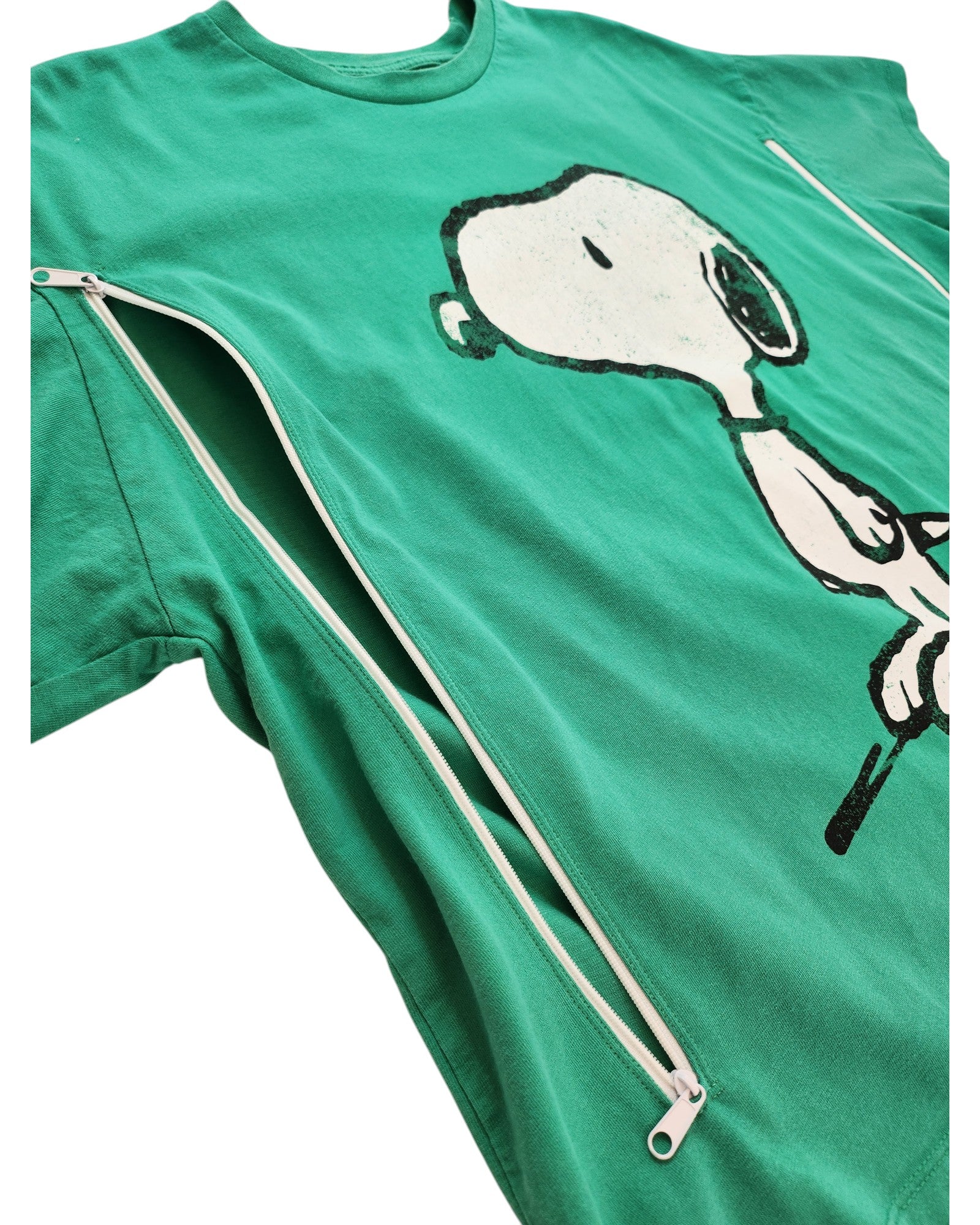 The Upcycled Breastfeeding & Pumping Peanuts Snoopy T-shirt by Touched Out Mama in green features a cartoon dog design. Made from eco-friendly materials, it includes functional zippers along the sides for a unique flair.