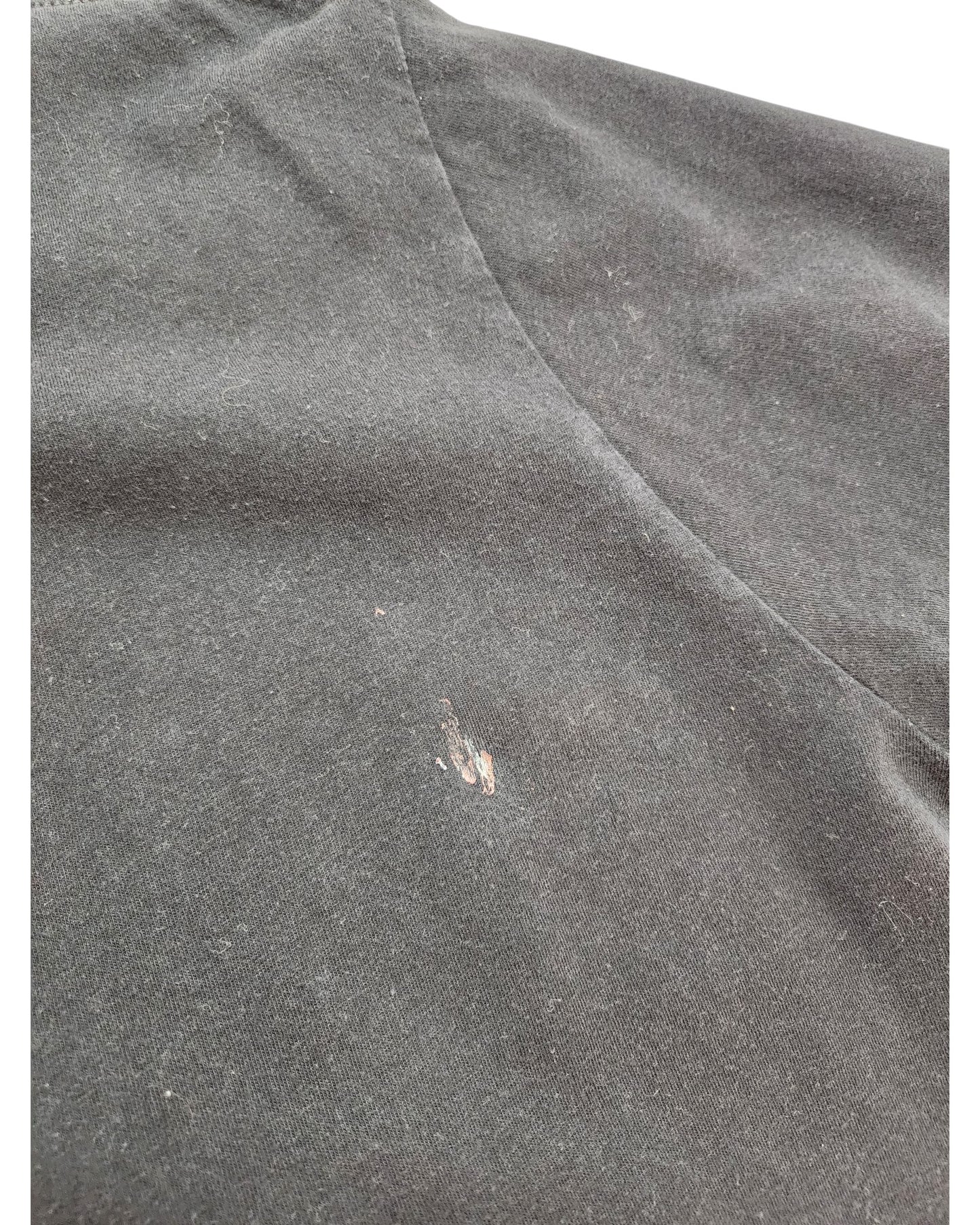 A close-up of the eco-friendly Upcycled Breastfeeding & Pumping Game of Thrones t-shirt (size L) by touched out mama in black, showing a small light-colored stain or scuff mark on the fabric.