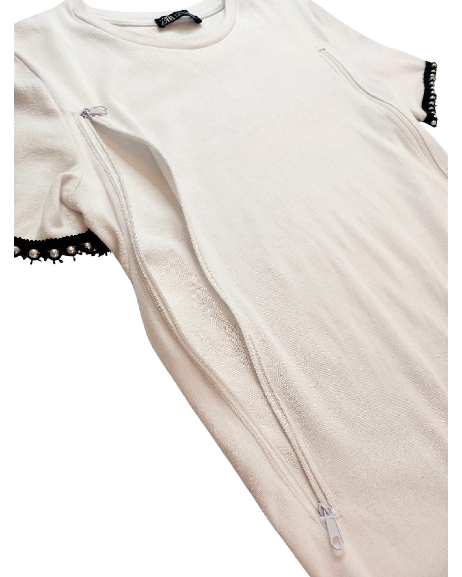 The Upcycled Breastfeeding & Pumping T-shirt by touched out mama is a white short-sleeved tee with black lace trim on the edges and two vertical zippers down the front, part of our eco-friendly collection.