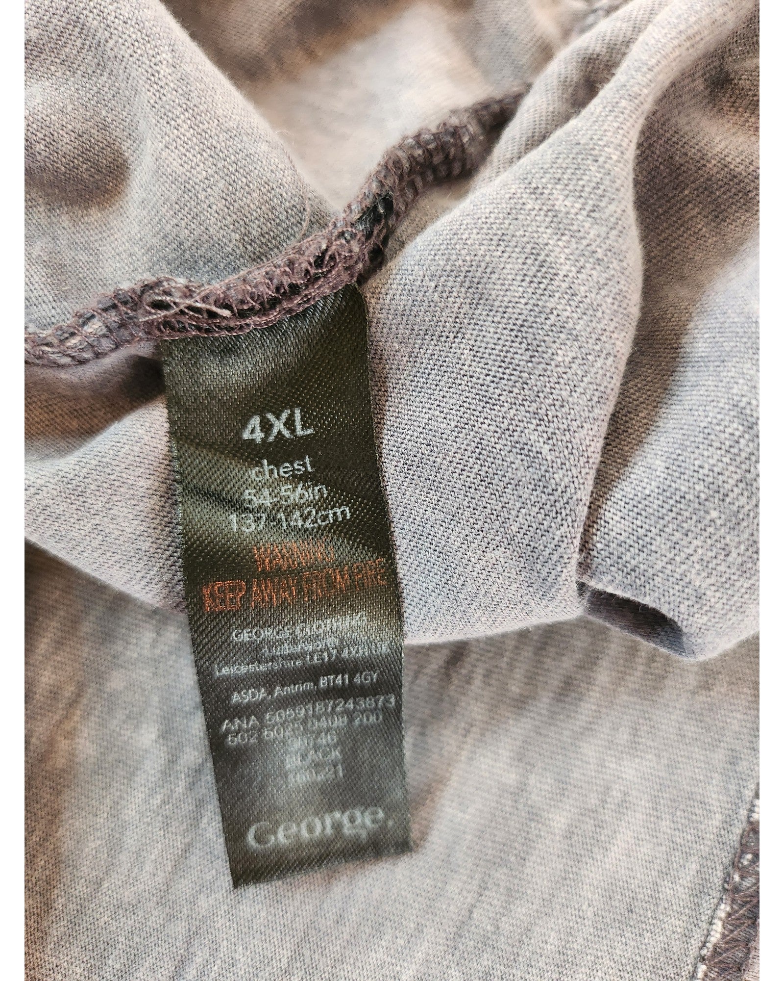 Close-up of the touched out mama label on the upcycled 4XL gray Rolling Stones t-shirt for breastfeeding/pumping shows chest size 54-56 inches (137-142 cm) with care instructions to KEEP AWAY FROM FIRE.