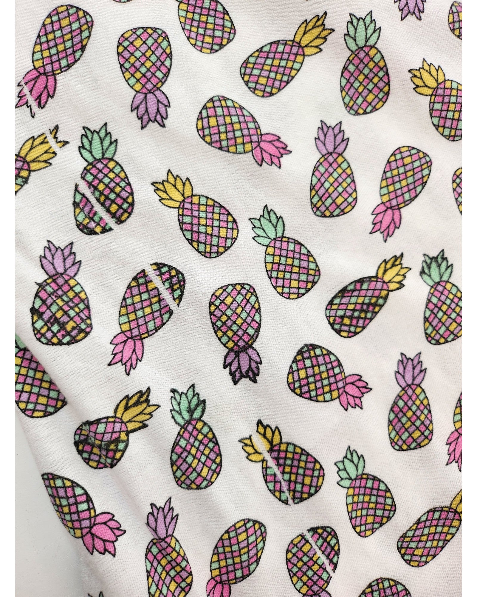 The Upcycled Breastfeeding & Pumping Pineapple t-shirt (UK20) by Primark is a white tee with colorful, checkered pineapples in various directions—made from preloved clothing for an eco-friendly choice.