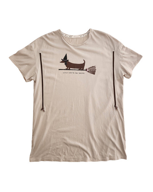 The Tu Upcycled Breastfeeding & Pumping Witch Dog T-shirt Nightdress (L) is a beige top featuring a dog in a witch hat on a broomstick and the phrase “WITCH WAY TO THE TREATS.”.