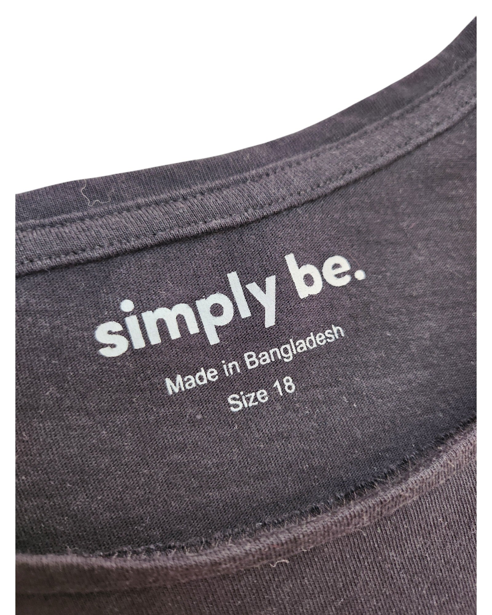 Close-up of a black Simply Be neck label reading simply be. Made in Bangladesh, Size UK18—an upcycled breastfeeding/pumping Black Love t-shirt, ideal for fans of preloved fashion.