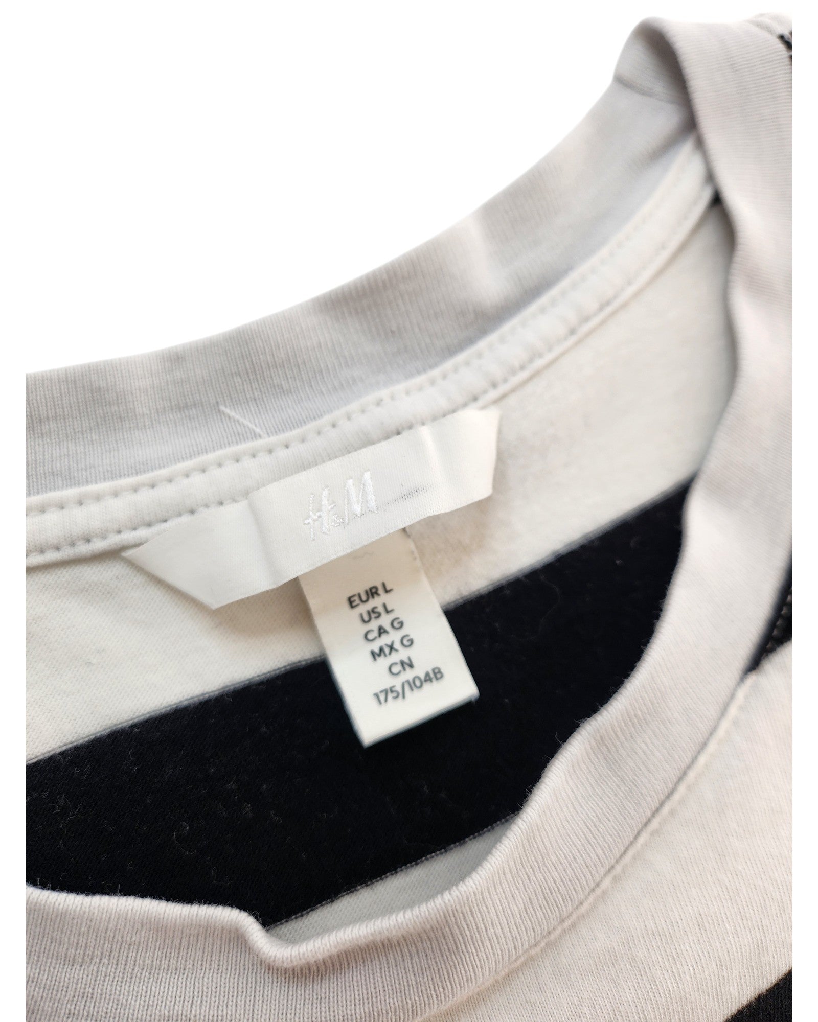 Close-up of an H&M label inside an Upcycled Breastfeeding & Pumping Black/White Stripe t-shirt (L), showing size info for regions: EUR L, US L, CA G, MX G, and 175/104B.