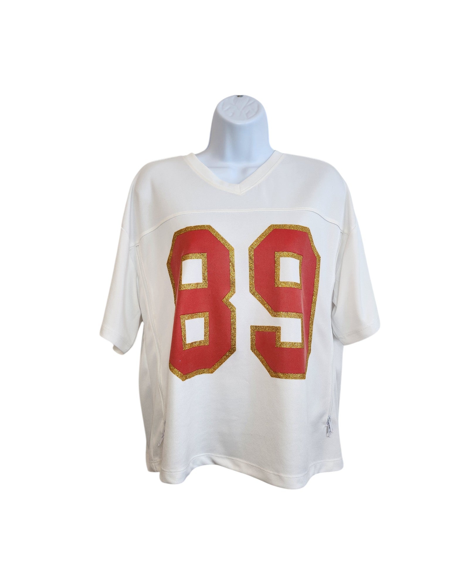 The Messy Bun Just Chillin Upcycled Breastfeeding & Pumping 89 Swiftie Football Jersey t-shirt (size L) features short sleeves and a bold red 89 outlined in gold. Displayed on a mannequin against a white background.