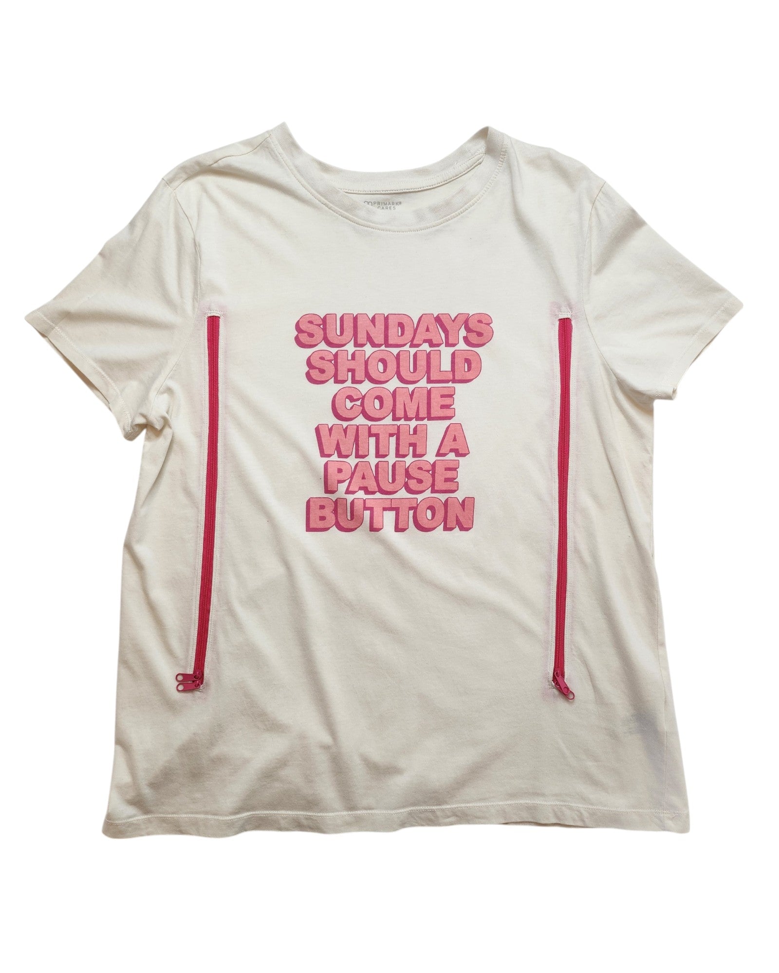 Primark’s Upcycled Breastfeeding & Pumping Sundays Pause Button t-shirt (L, UK14/16) is a white tee with pink side zippers for easy nursing and features “SUNDAYS SHOULD COME WITH A PAUSE BUTTON” in pink text on the front.