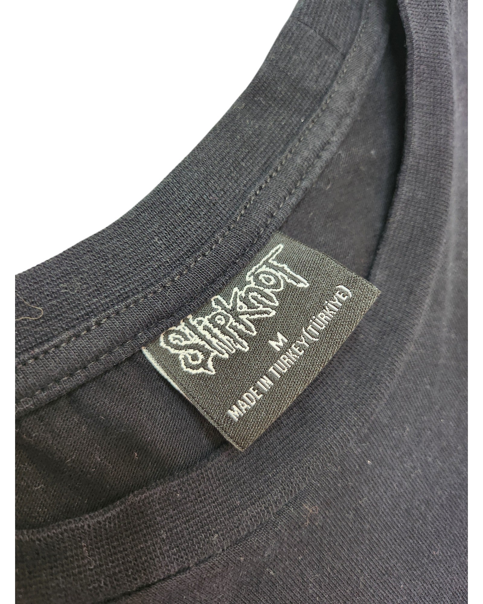 Close-up of a black t-shirt collar with a Primark label reading Upcycled Breastfeeding & Pumping Black/Blue Slipknot Band t-shirt M, highlighting eco-friendly, thoughtfully crafted materials.
