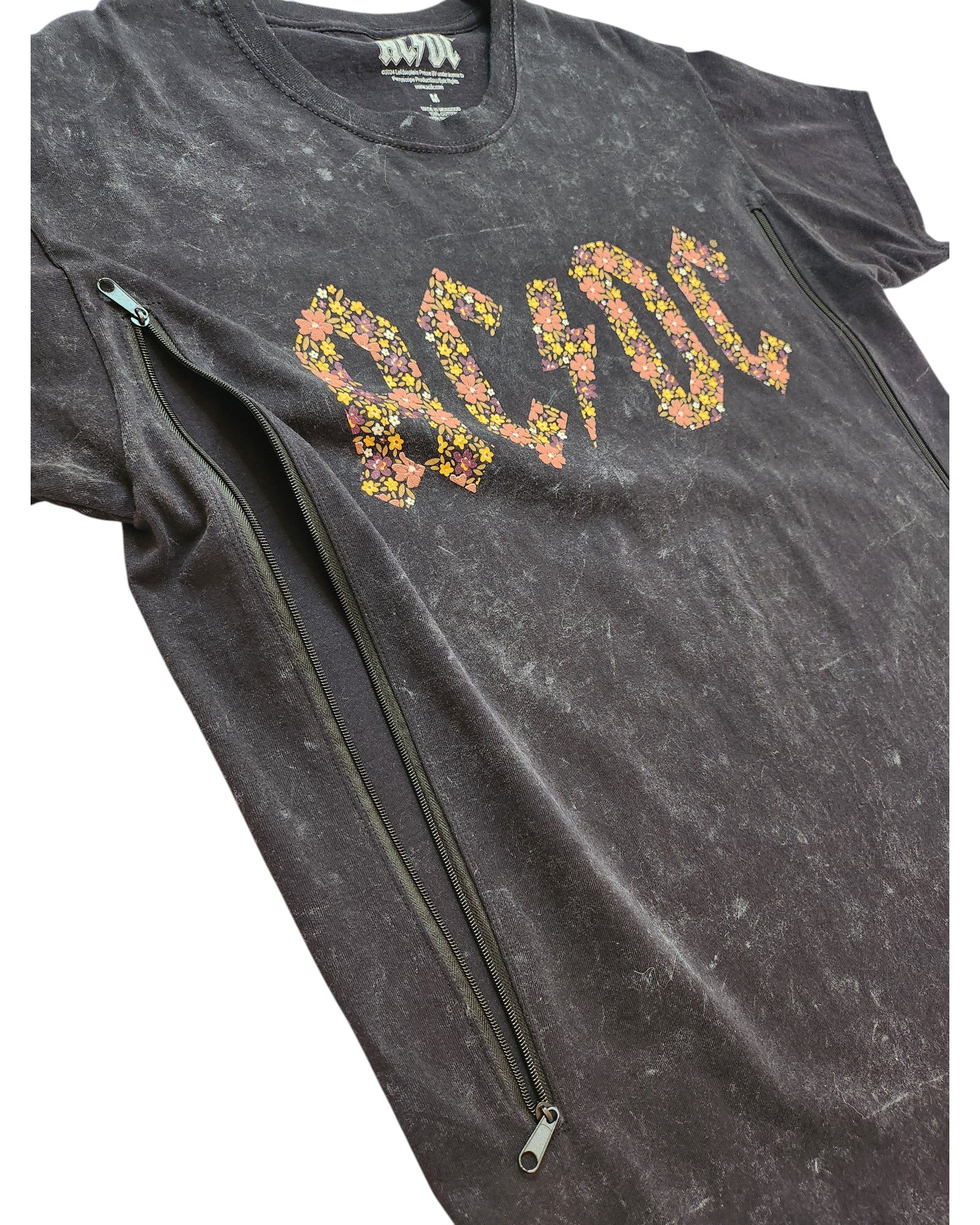 The Upcycled Breastfeeding & Pumping Floral AC/DC Band t-shirt (M) by AC/DC is a black marble-washed tee with a yellow and pink floral logo and two diagonal black zippers—ideal for nursing or pumping.