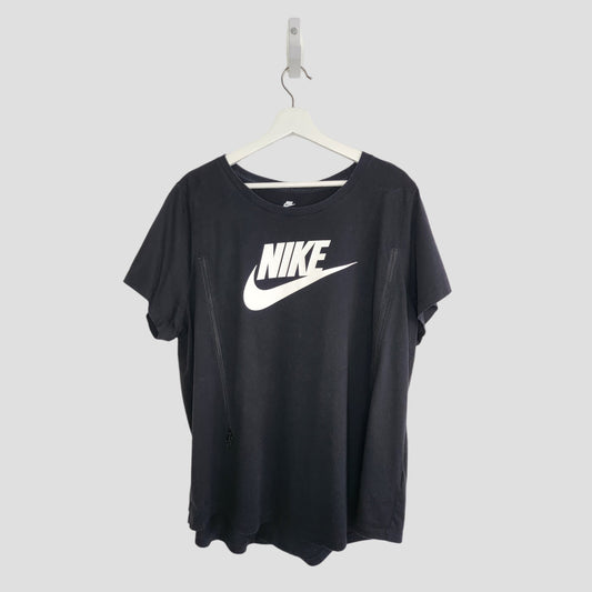 An upcycled XXL black Nike t-shirt for breastfeeding and pumping, featuring a large white Nike logo and swoosh on the front, hangs on a white hanger against a plain light gray background.